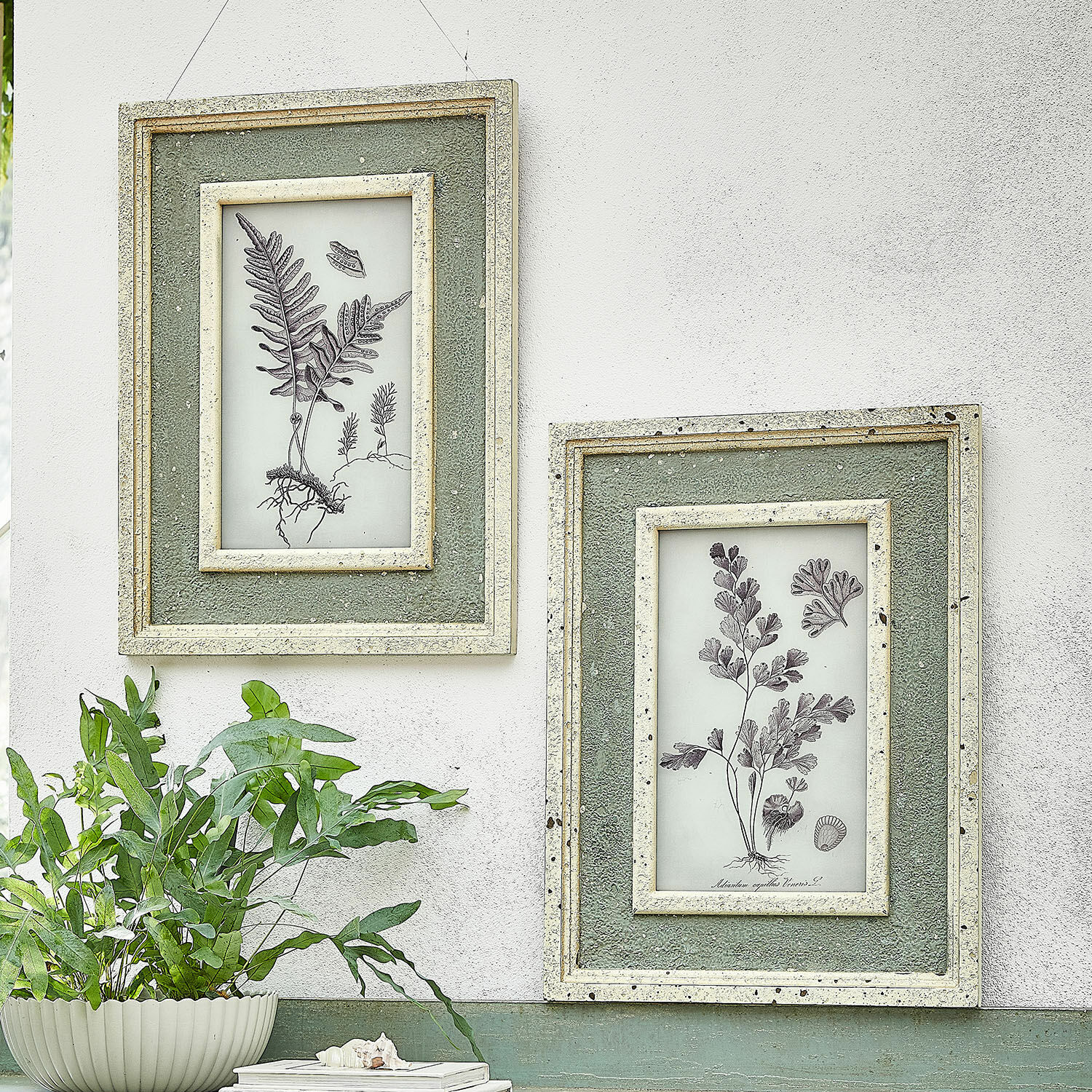 Schilderij set van 2 Cerilav Twee groene wandlijsten met botanische tekeningen en textuur aan witte muur in vintage stijl