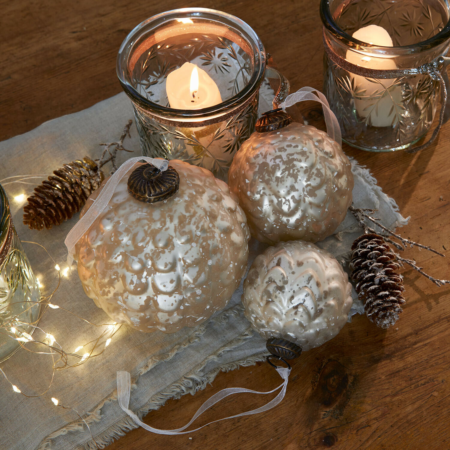 Kerstbal set van 6 Domara Set van drie parelmoer glazen kerstballen met decoratief patroon en kaarslicht op de achtergrond