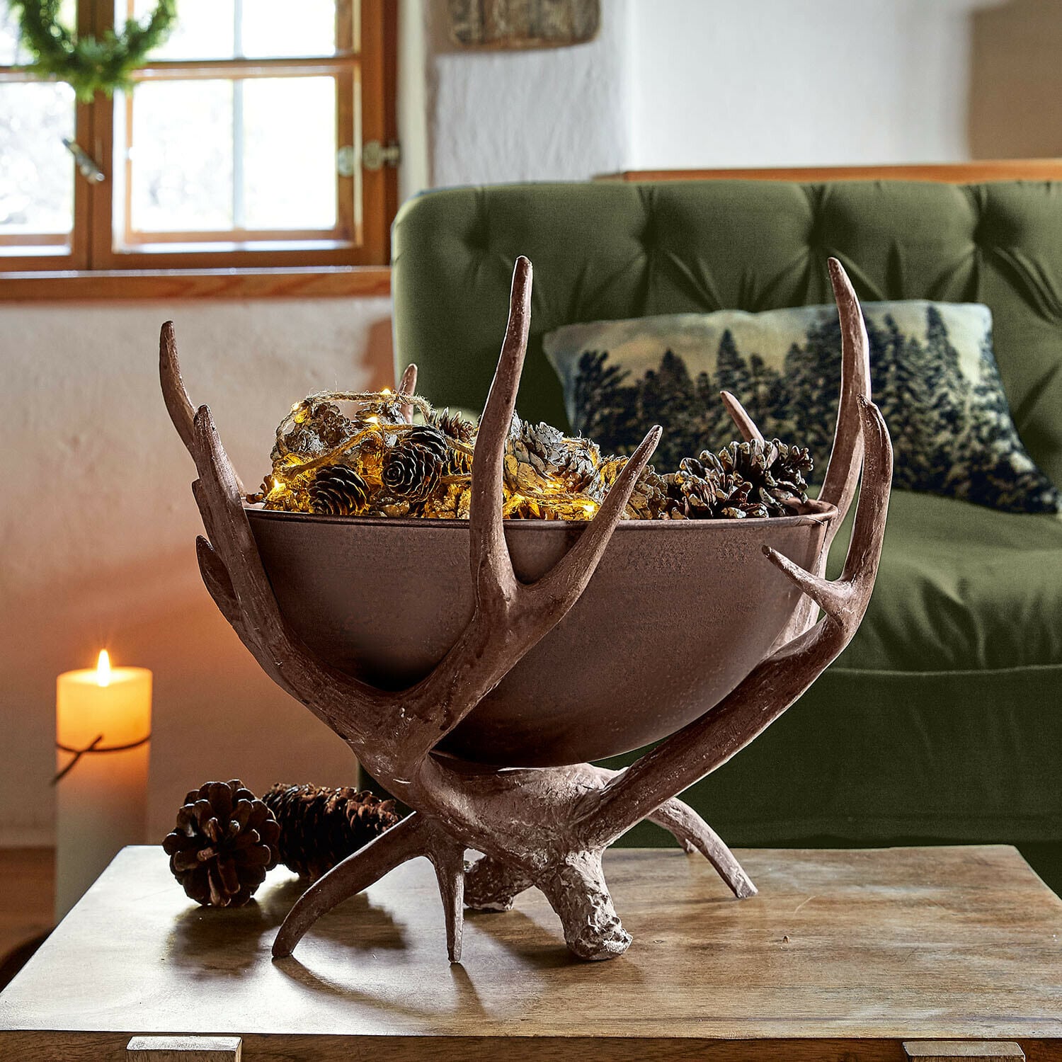 Coupe décorative Morlaix Coupe décorative en cuivre et bois de cerf avec pommes de pin et guirlande lumineuse sur table en bois