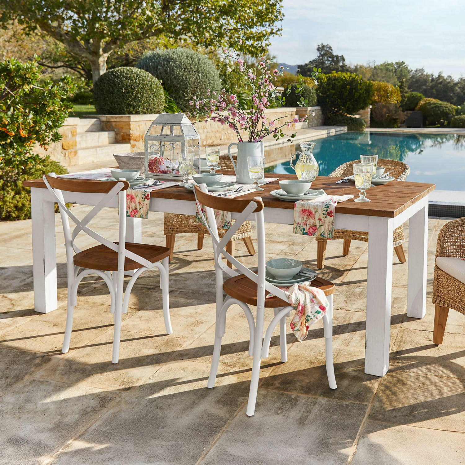 Tafel Kirkdale Houten tuintafel met witte poten en rustieke stoelen bij het zwembad