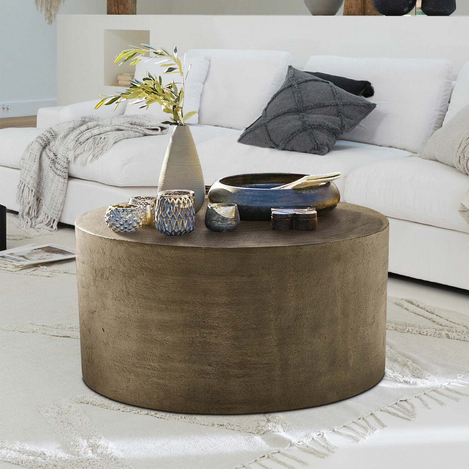 Salontafel Lexy Ronde salontafel van bruin beton op lichte vloerkleed in moderne woonkamer met witte bank
