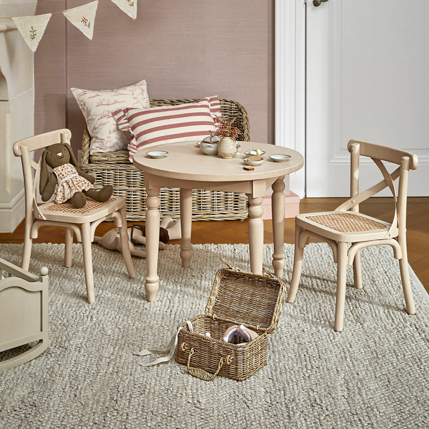Groupe de sièges pour enfants Sourila Table ronde en bois beige avec chaises à assise tressée dans une chambre d'enfant avec jouets et tapis