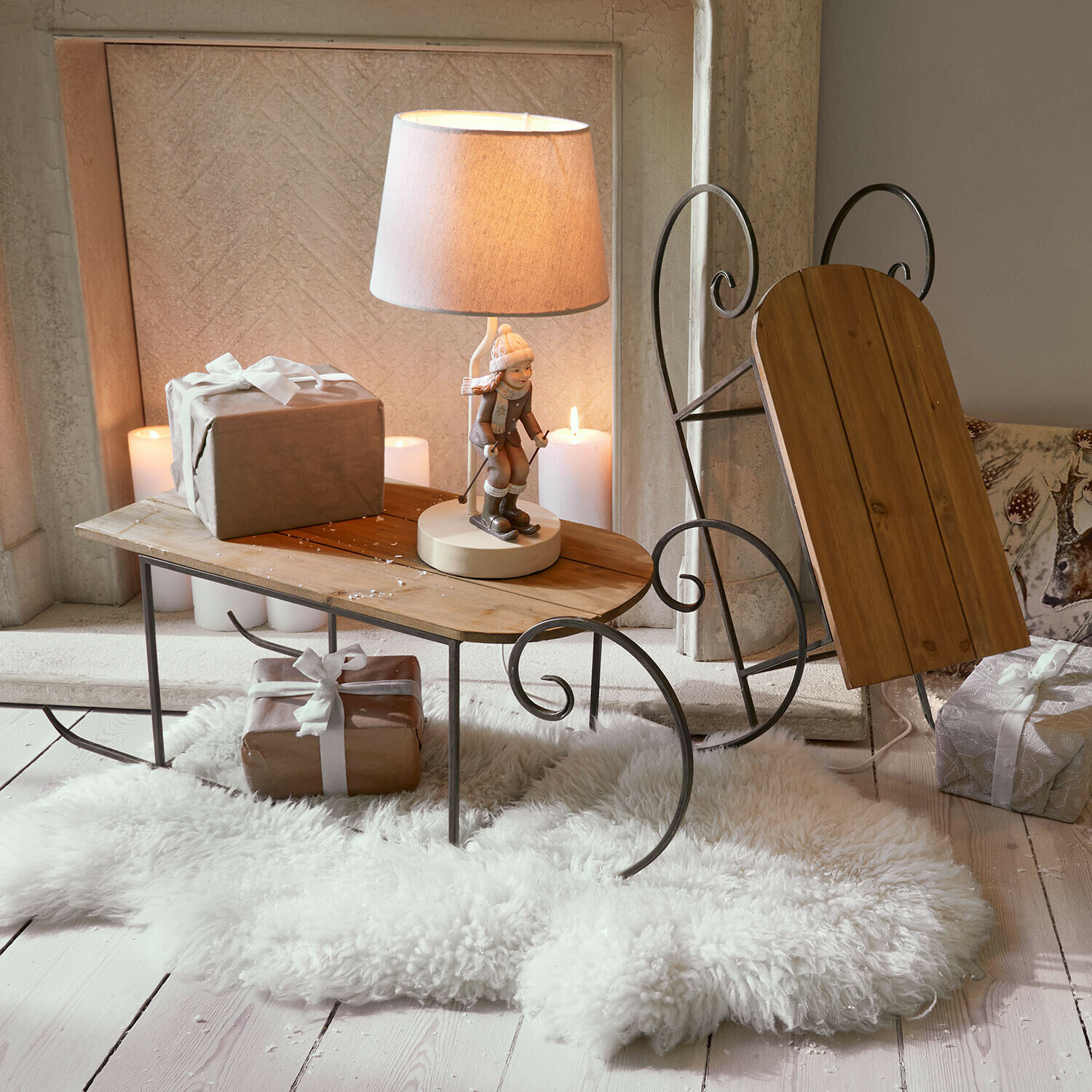 Lot de 2 traîneaux décoratifs Skalara Table en bois et métal en forme de luge avec lampe et cadeaux sur tapis en fausse fourrure blanc