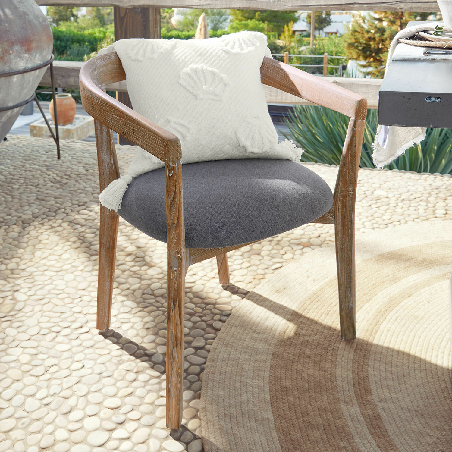 Chaise Lunebois Chaise en bois avec assise grise et coussin décoratif blanc sur terrasse ensoleillée