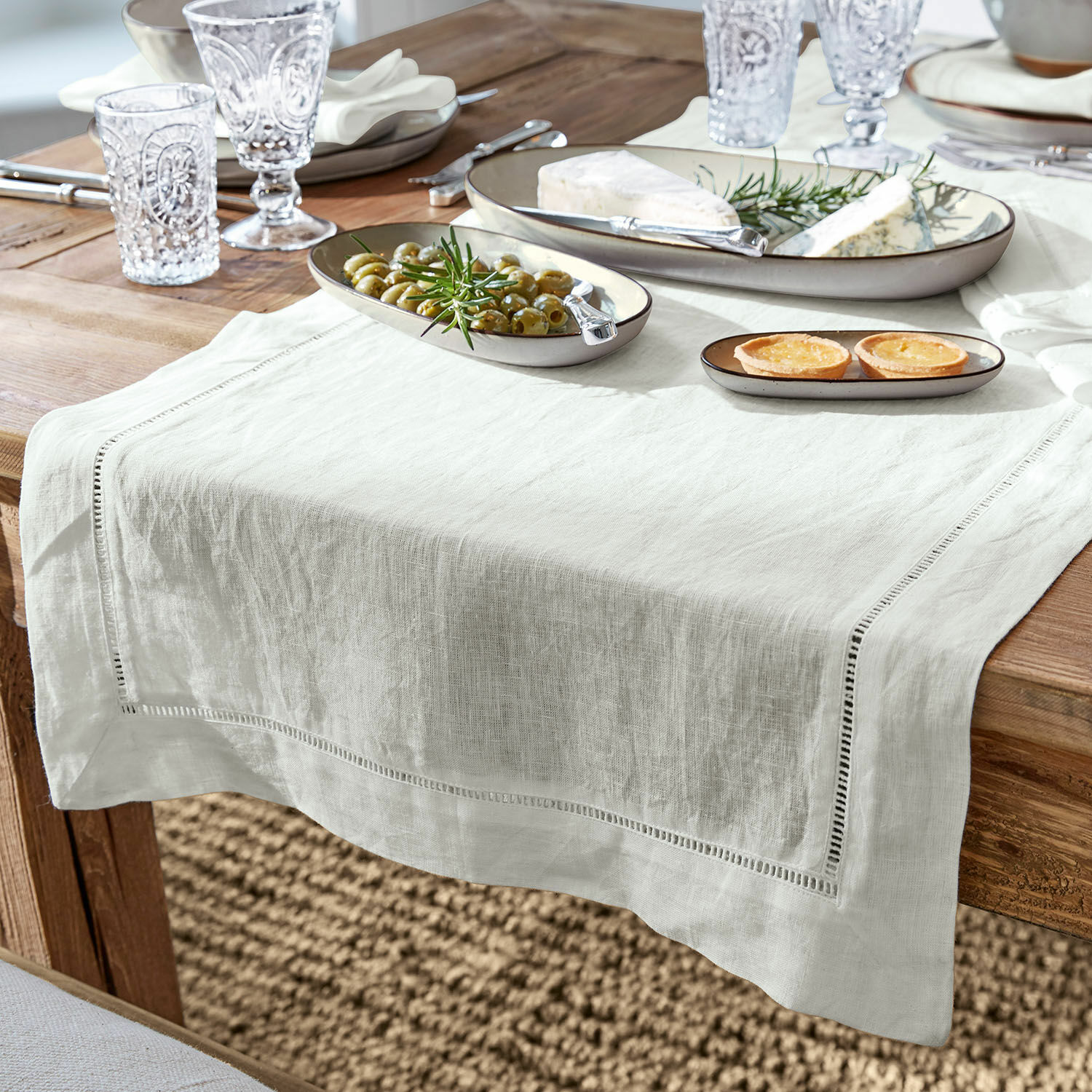 Tafelloper Covent Garden Witte linnen tafelloper op houten tafel met borden en hapjes, stijlvolle tafeldecoratie