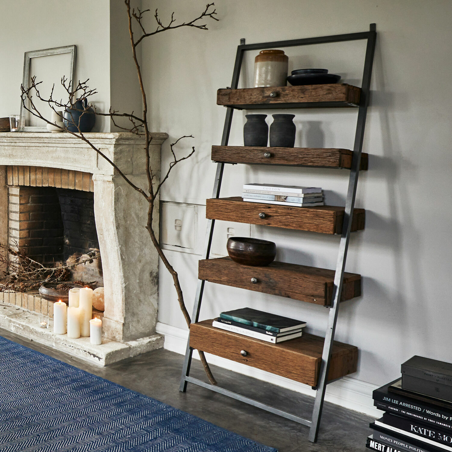 Étagère Rosemill Étagère en bois et métal style loft avec tiroirs, décorations et livres dans un salon moderne