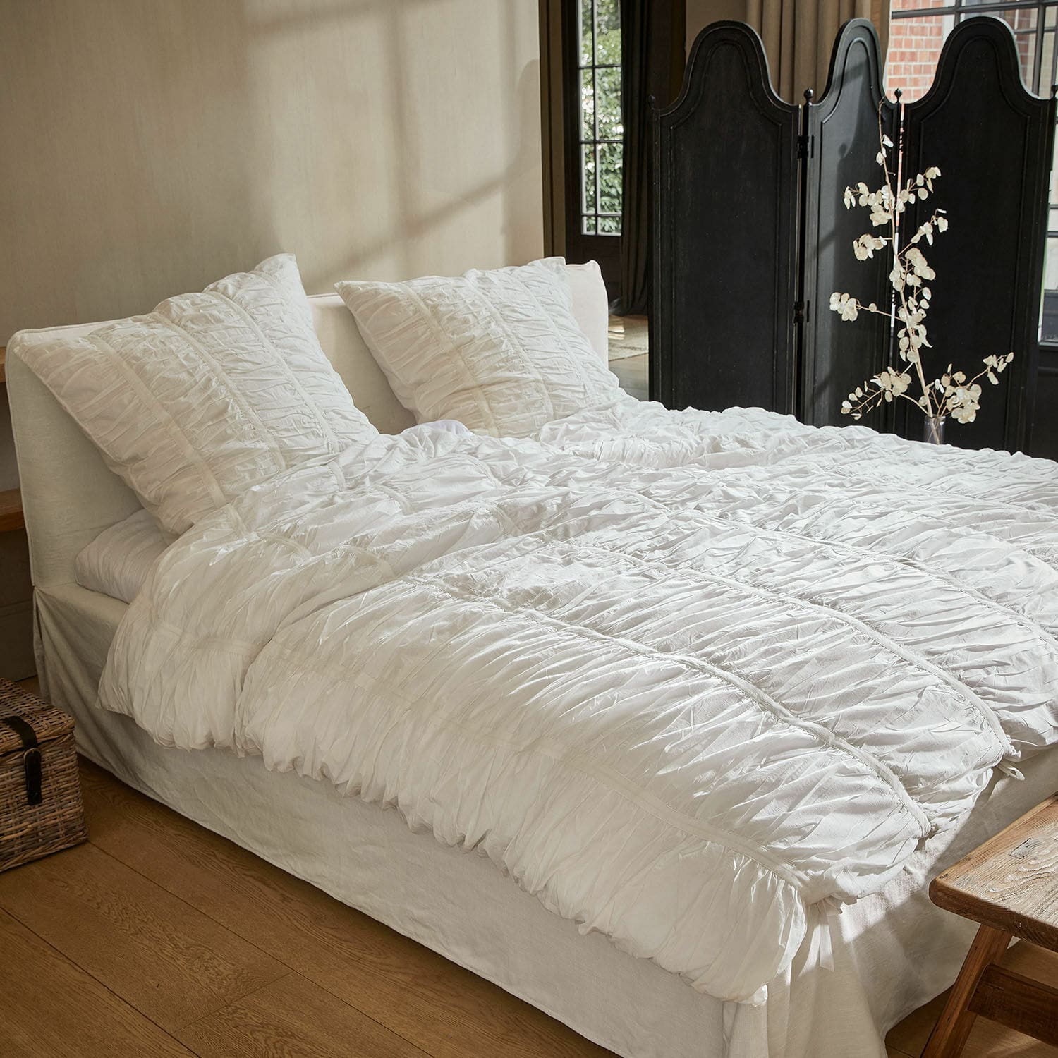 Beddengoed Magdelen Witte katoenen beddengoed met plooien op bed in gezellige slaapkamer