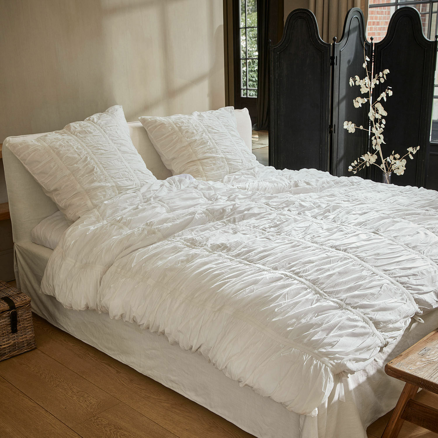 Beddengoed Magdelen Witte katoenen beddengoed met plooien op bed in gezellige slaapkamer