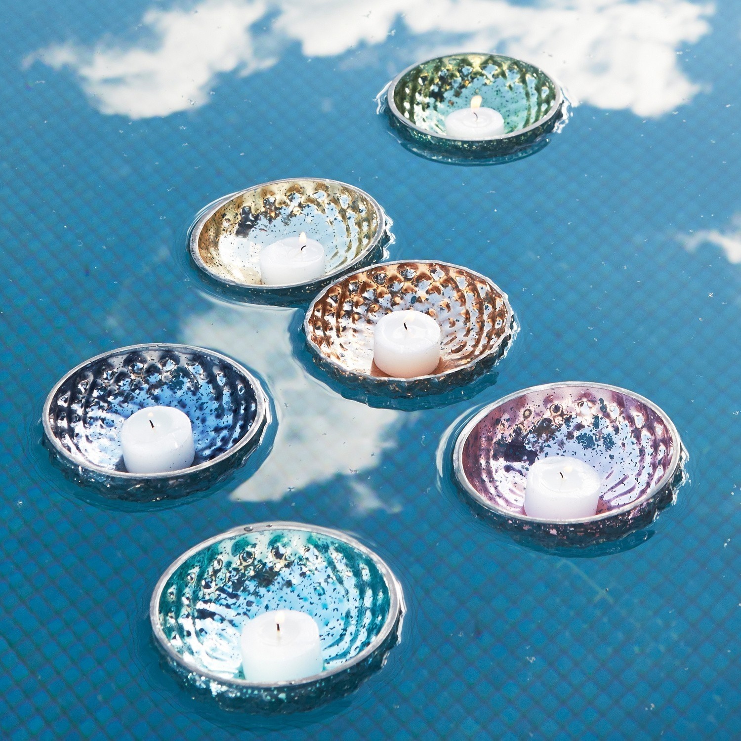 Lot de 6 photophores flottants Leela Bougeoirs flottants en céramique colorée avec bougies blanches sur l'eau d'une piscine, décoration extérieure