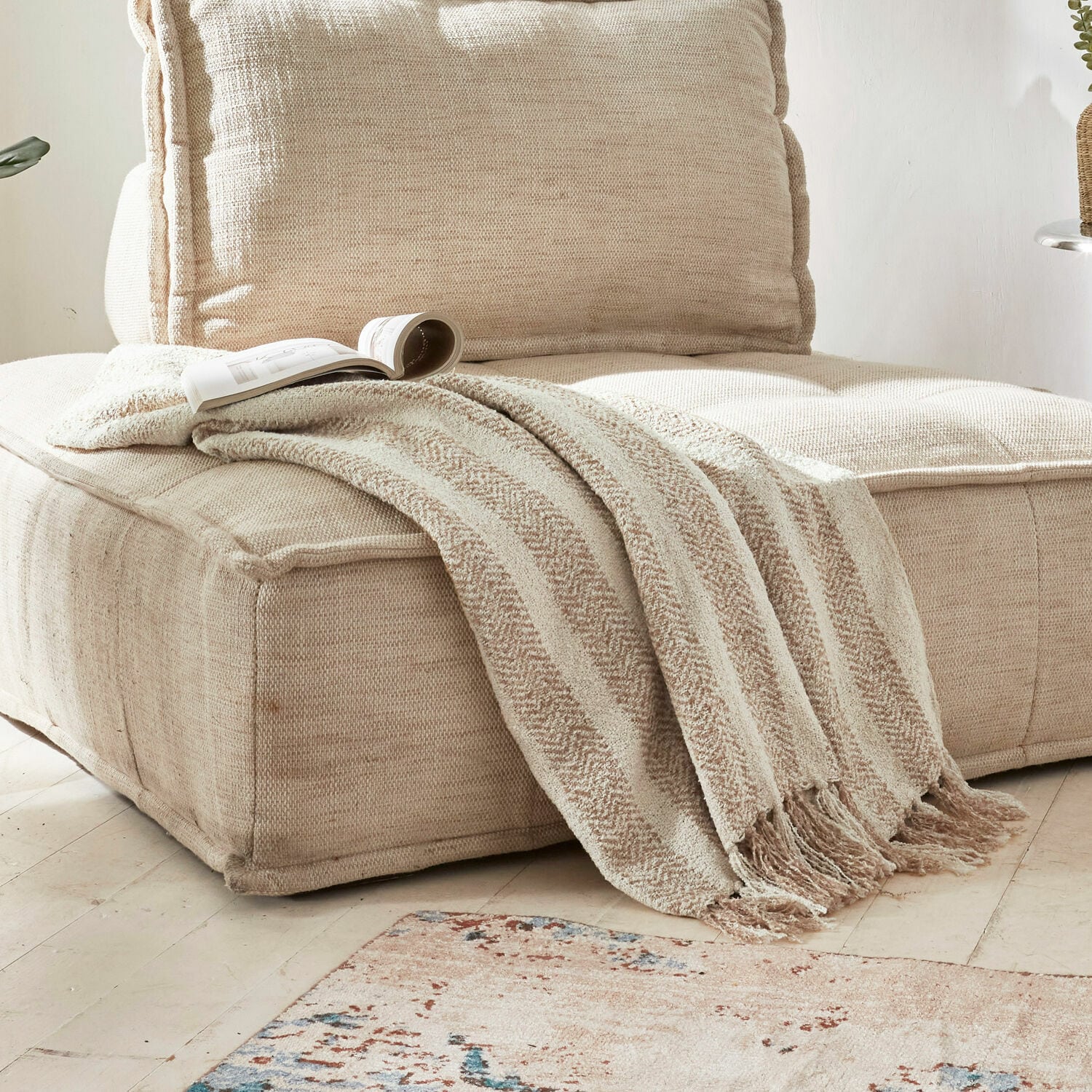 Plaid Aldan Beige zachte deken met franjes op beige stoffen bank in lichte woonkamer