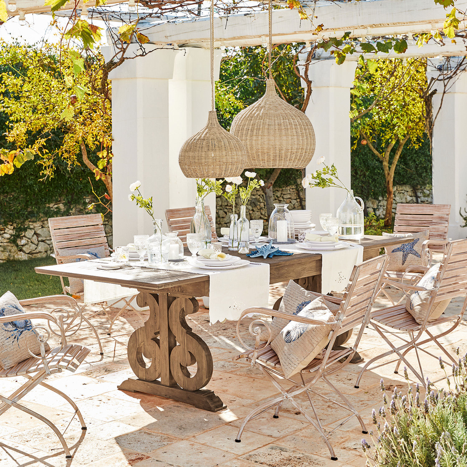 Table Concarneau Ensemble de mobilier de jardin avec table en bois et chaises en métal clair sur terrasse ensoleillée