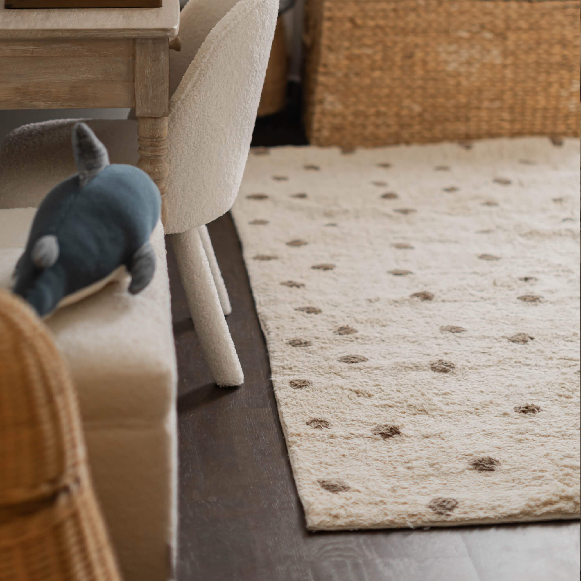 Tapis beige en matière douce avec des pois marron sur un sol foncé dans un salon