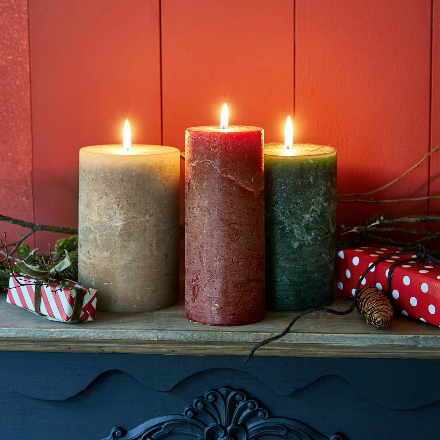 Kaars set van 3 Salis Drie kaarsen van was in beige, rood en groen op een houten plank met kerstdecoratie
