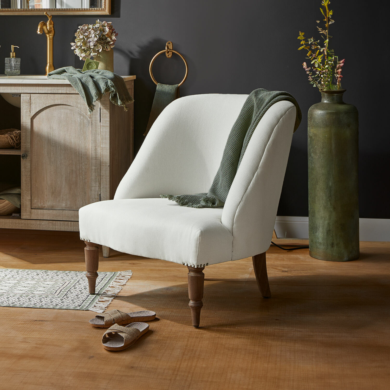 Leunstoel Maplewood Witte gestoffeerde stoel met houten poten en groene deken in modern interieur