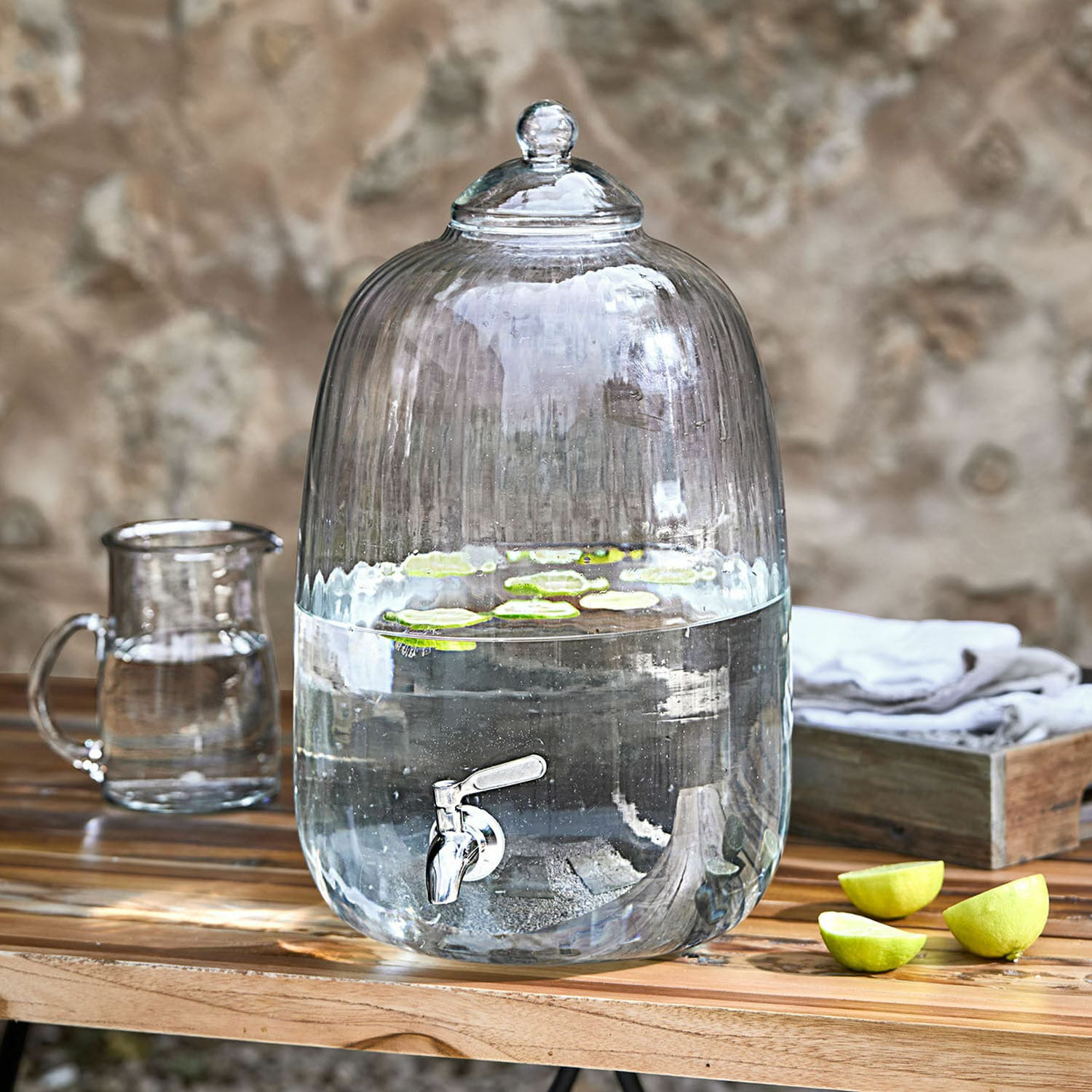 Drankdispenser Alindor Glazen waterdispenser met kraan en deksel, doorzichtig, met limoenplakjes op houten tafel
