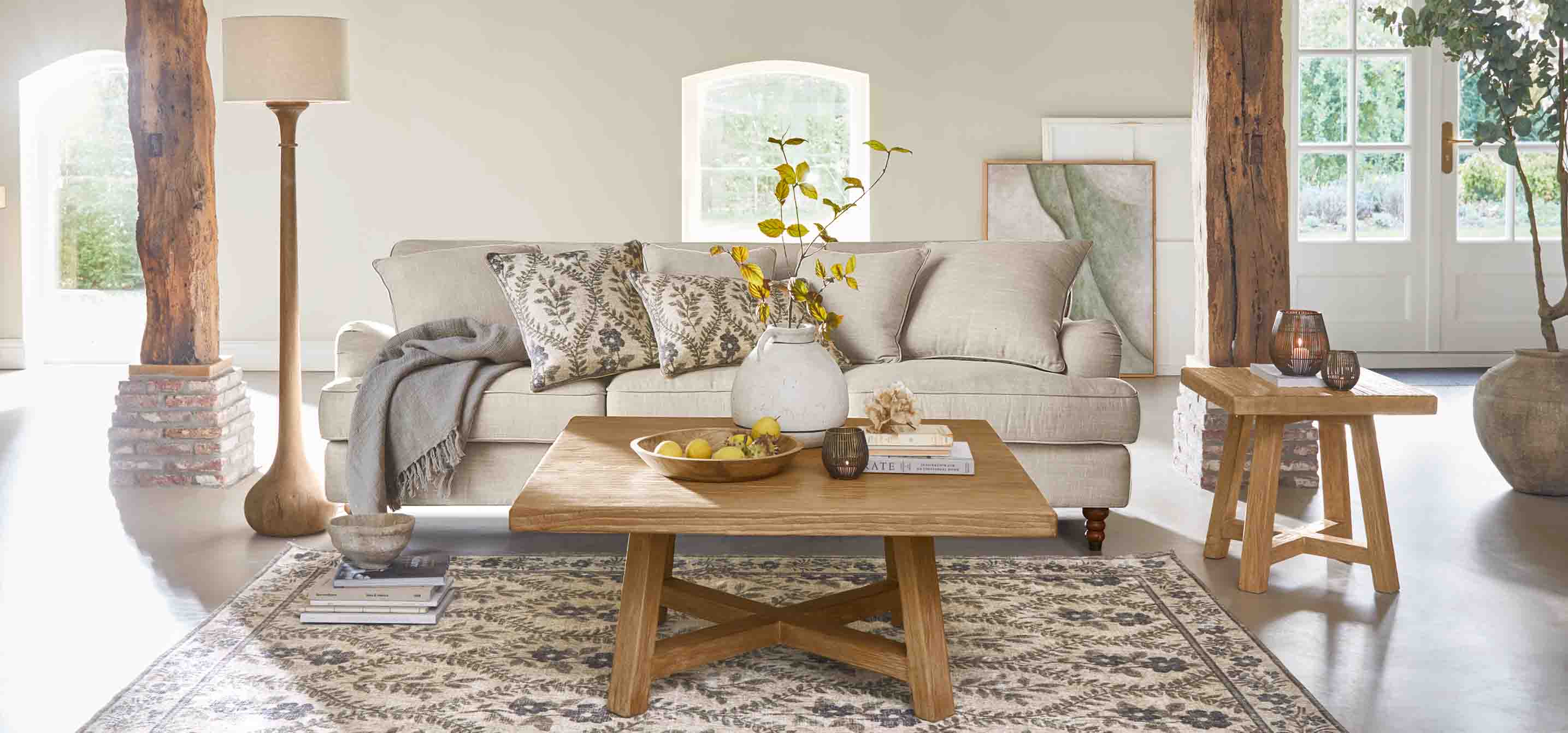 Gezellige woonkamer met beige bank, houten salontafel en natuurlijke decoraties in rustieke stijl