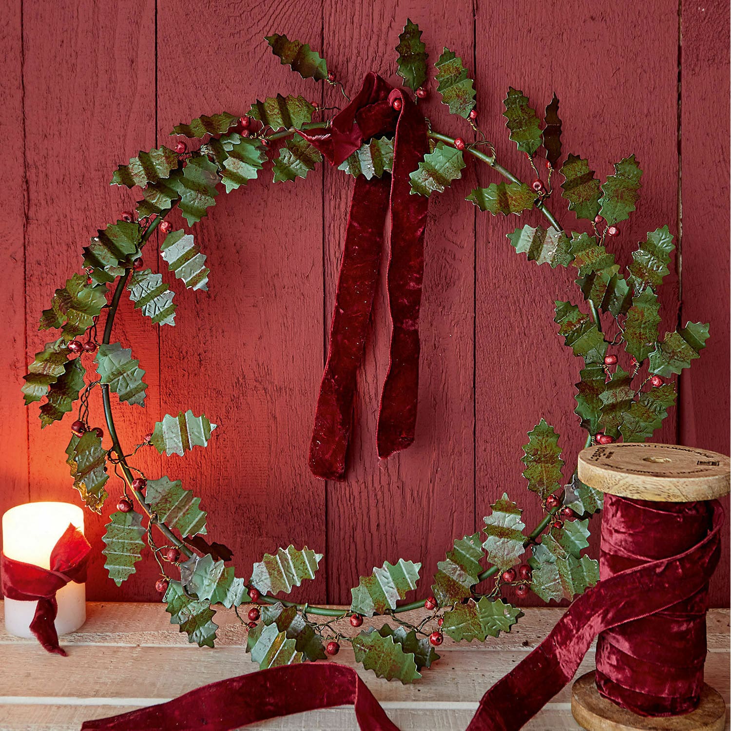 Krans Fleur Decoratieve krans van groene metalen bladeren met rode fluwelen lint op houten achtergrond