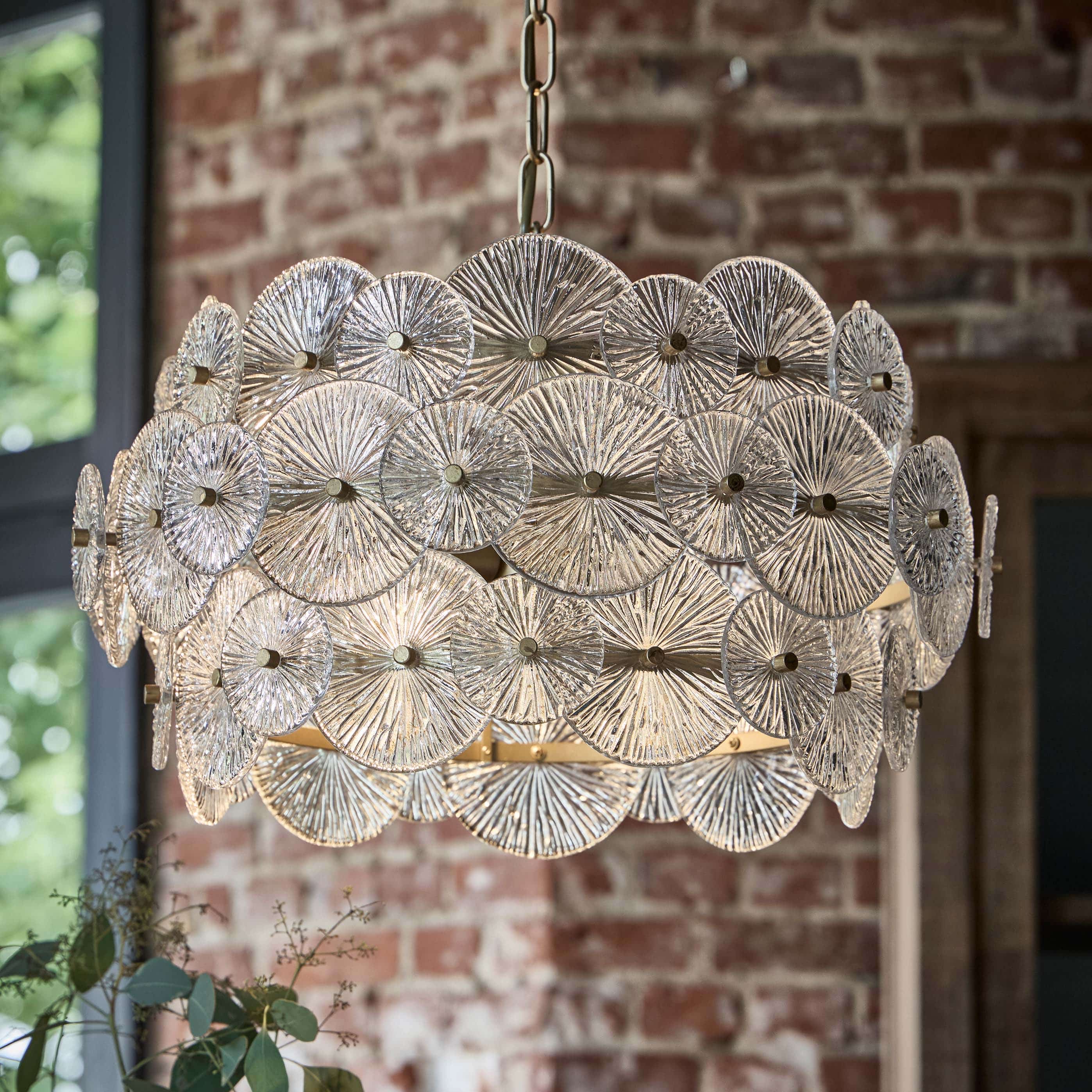 Hanglamp van helder glas met ronde patronen en metalen elementen, decoratieve plafondlamp