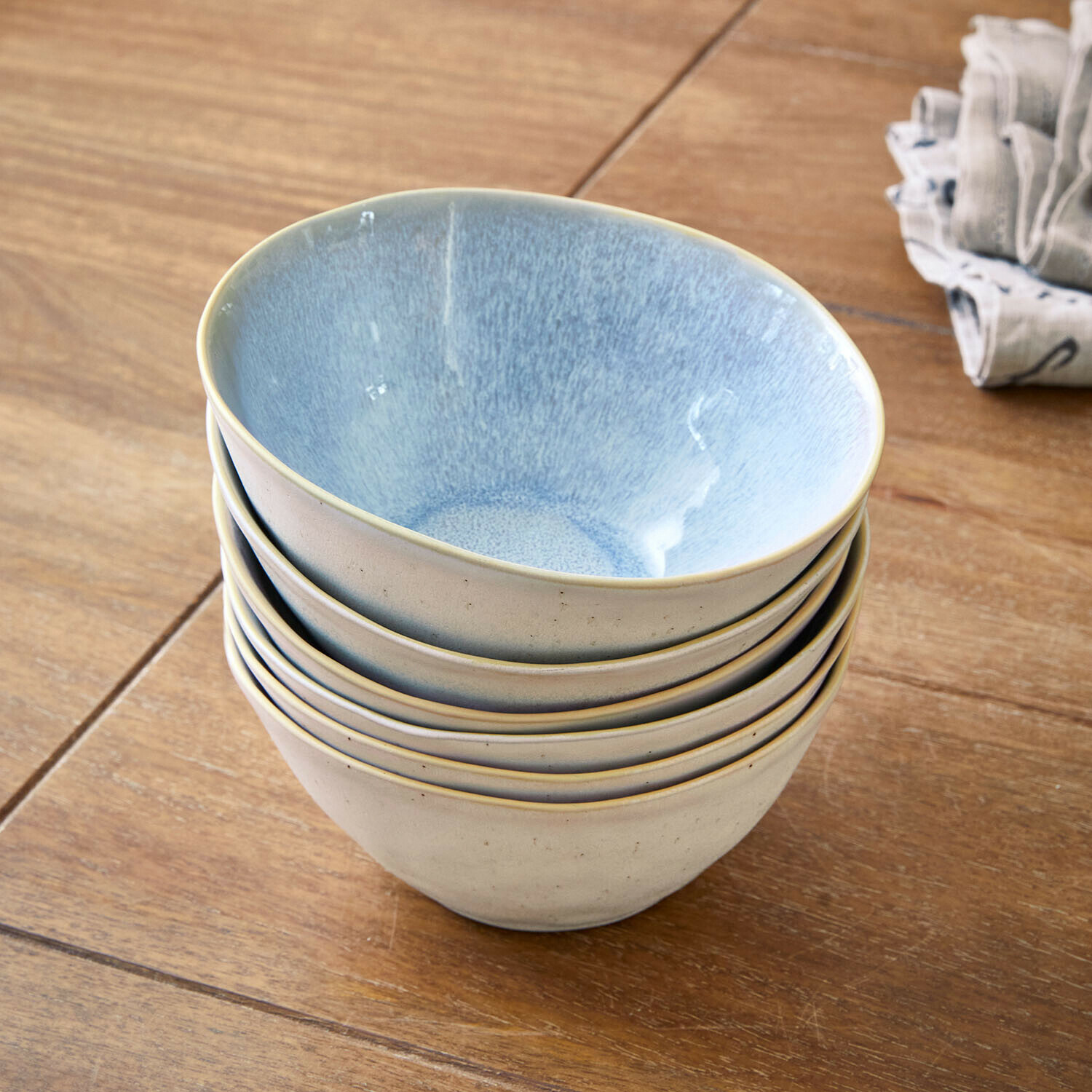 Kommetje set van 6 Vionette Set van zes crèmekleurige keramische kommen met blauwe binnenkant op houten tafel