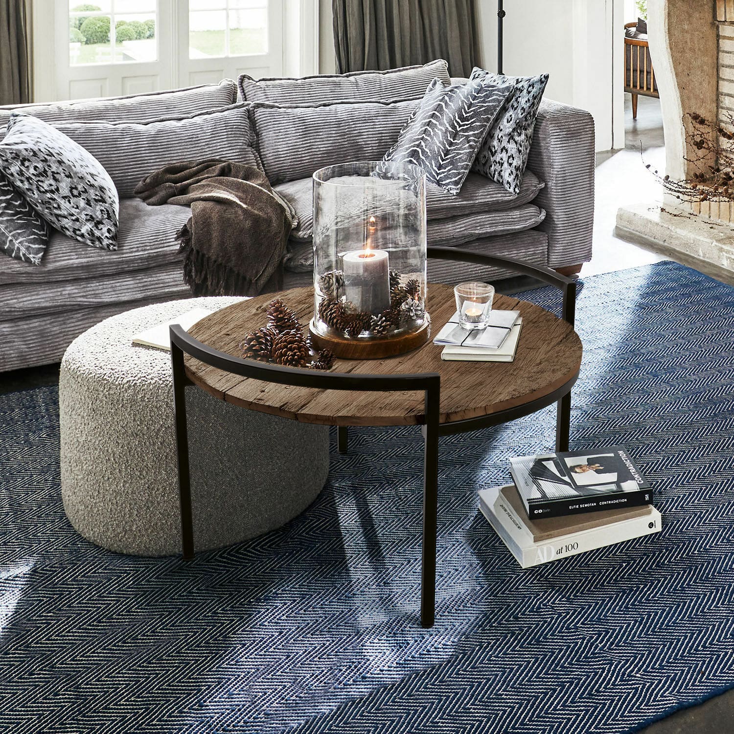 Salontafel Rosemill Ronde salontafel met houten blad en metalen frame op blauwe vloerkleed in woonkamer