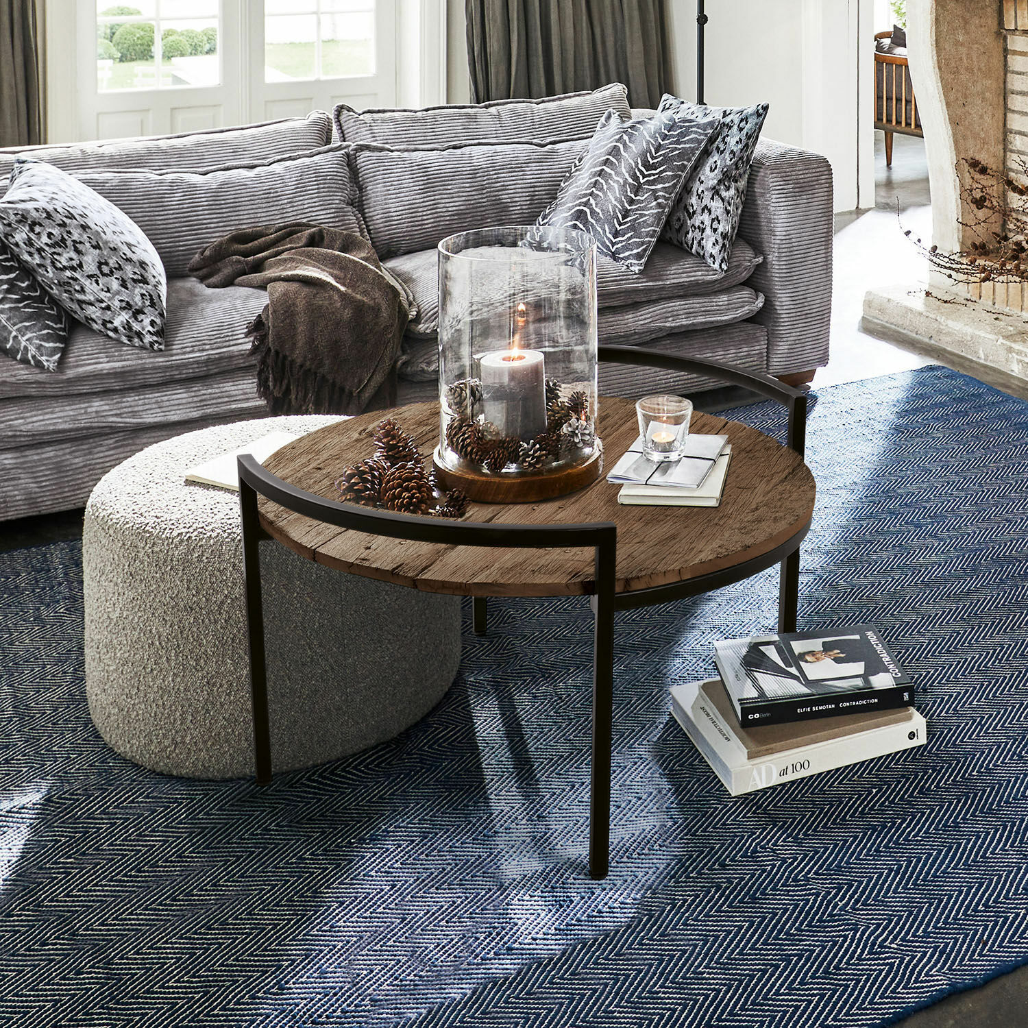 Salontafel Rosemill Ronde salontafel met houten blad en metalen frame op blauwe vloerkleed in woonkamer