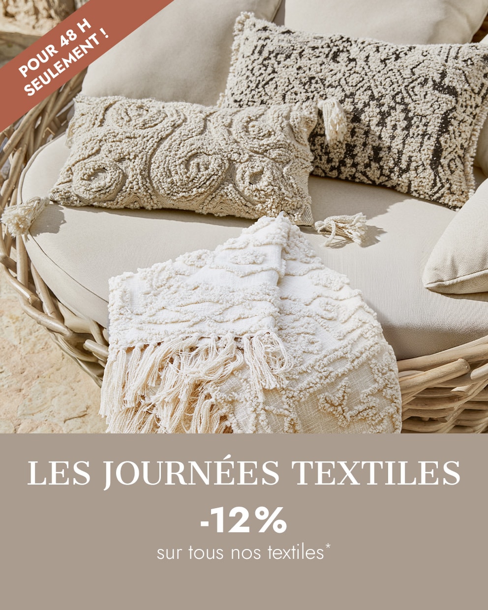 Coussins décoratifs beiges et plaid à franges sur canapé en osier, textiles d'intérieur