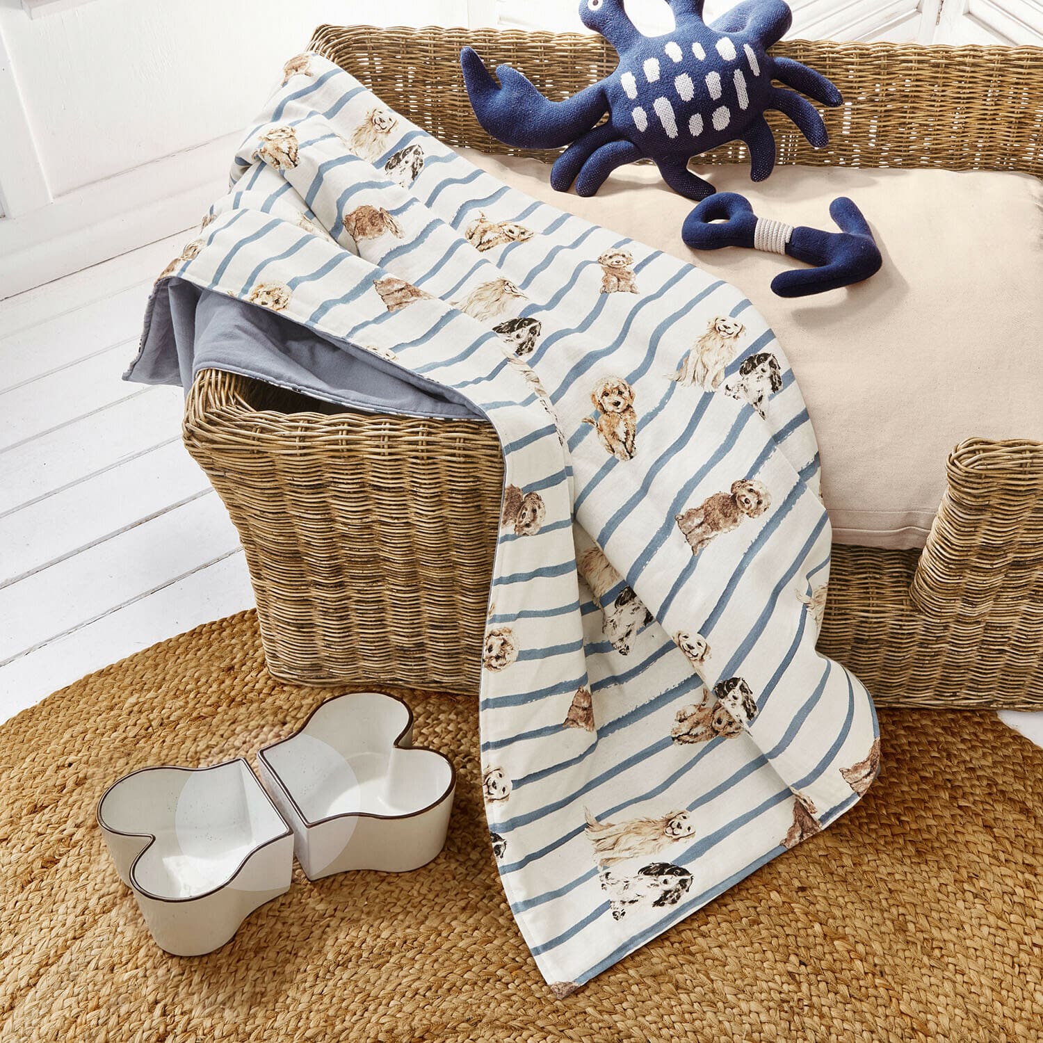 Plaid voor honden Schnuffelex Hondenkleed met blauwe strepen en hondenprint op rieten mand met speelgoed en voerbak in botvorm