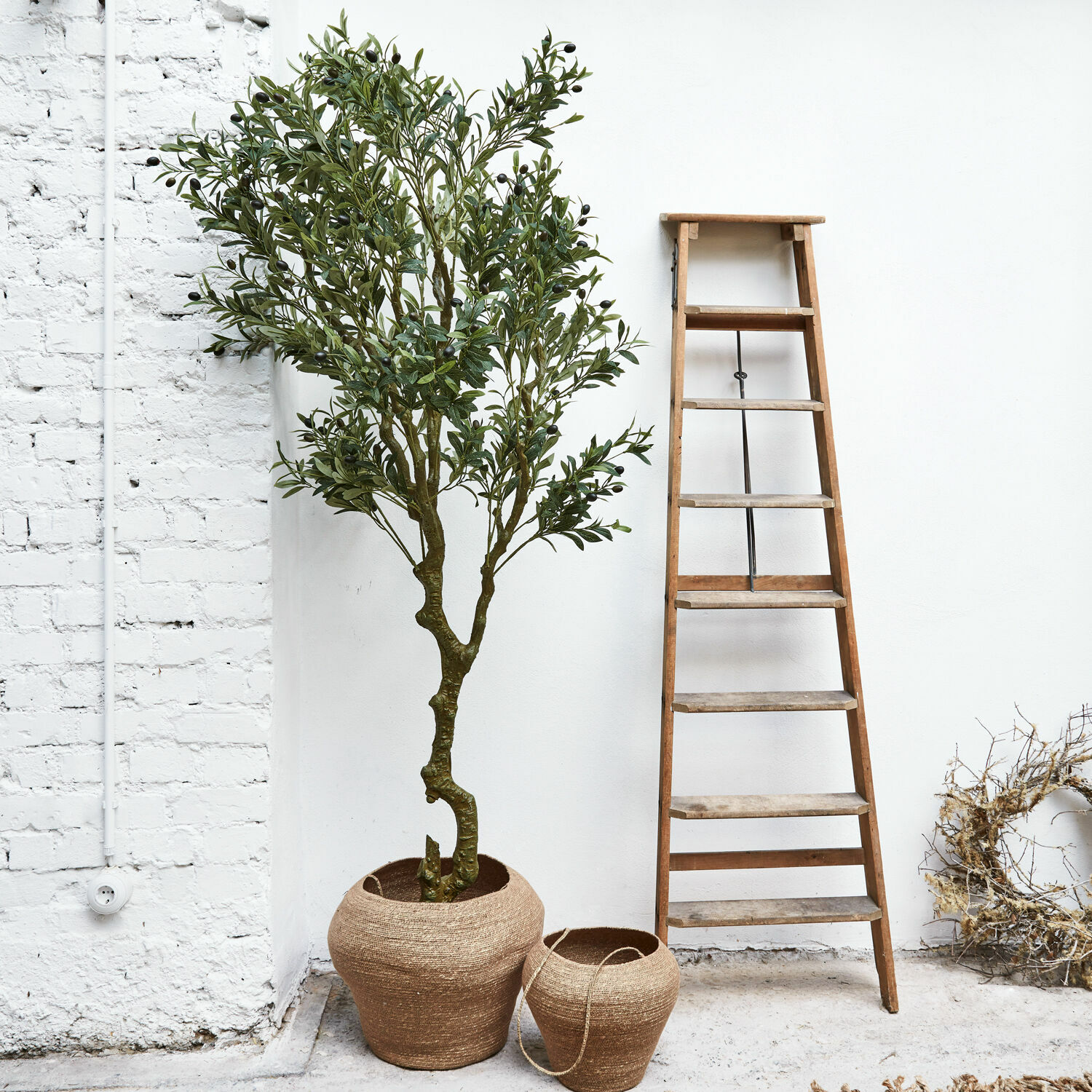 Plante décorative en pot Dambly Deux pots en jute marron naturel à côté d'une échelle en bois devant un mur blanc
