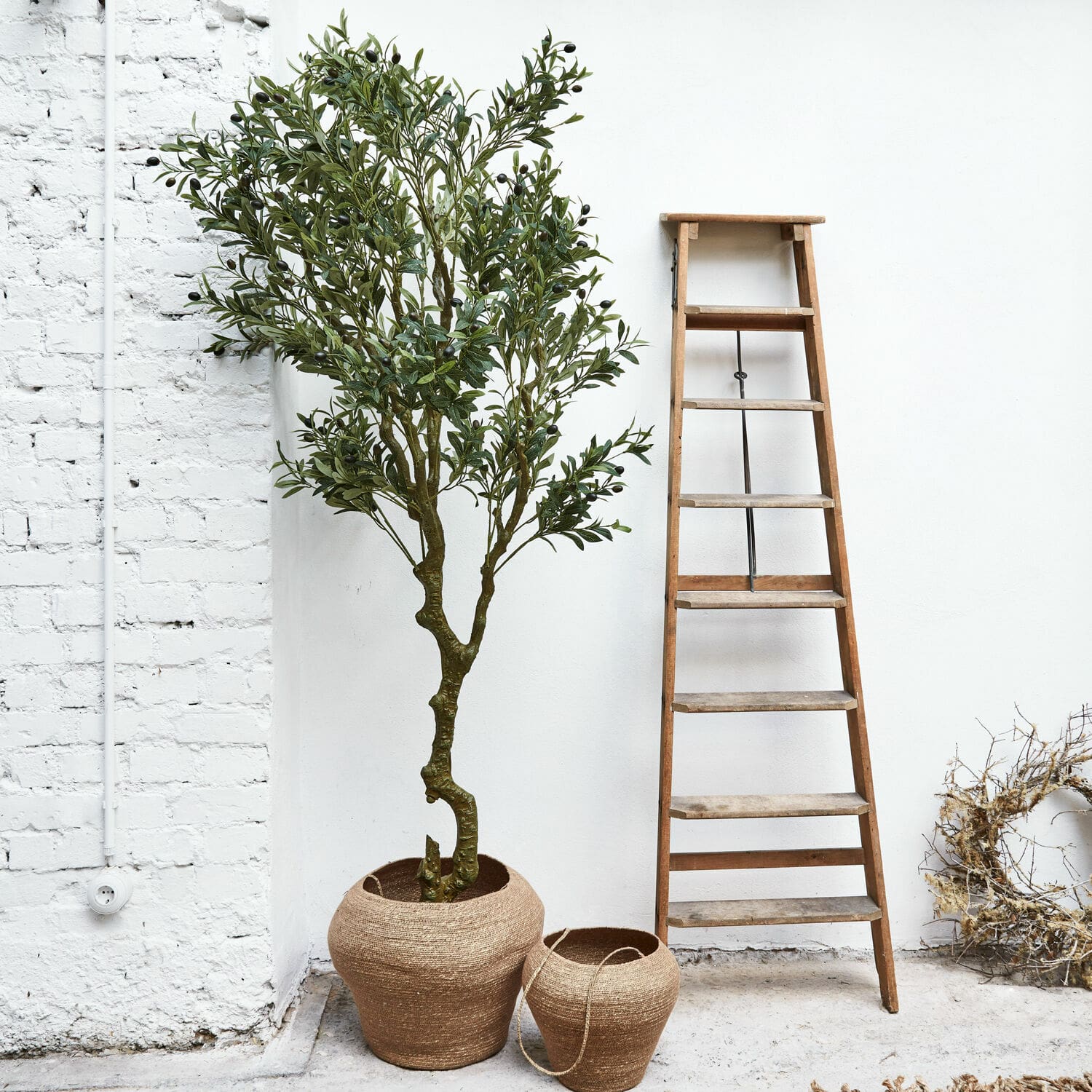 Plante décorative en pot Dambly Deux pots en jute marron naturel à côté d'une échelle en bois devant un mur blanc