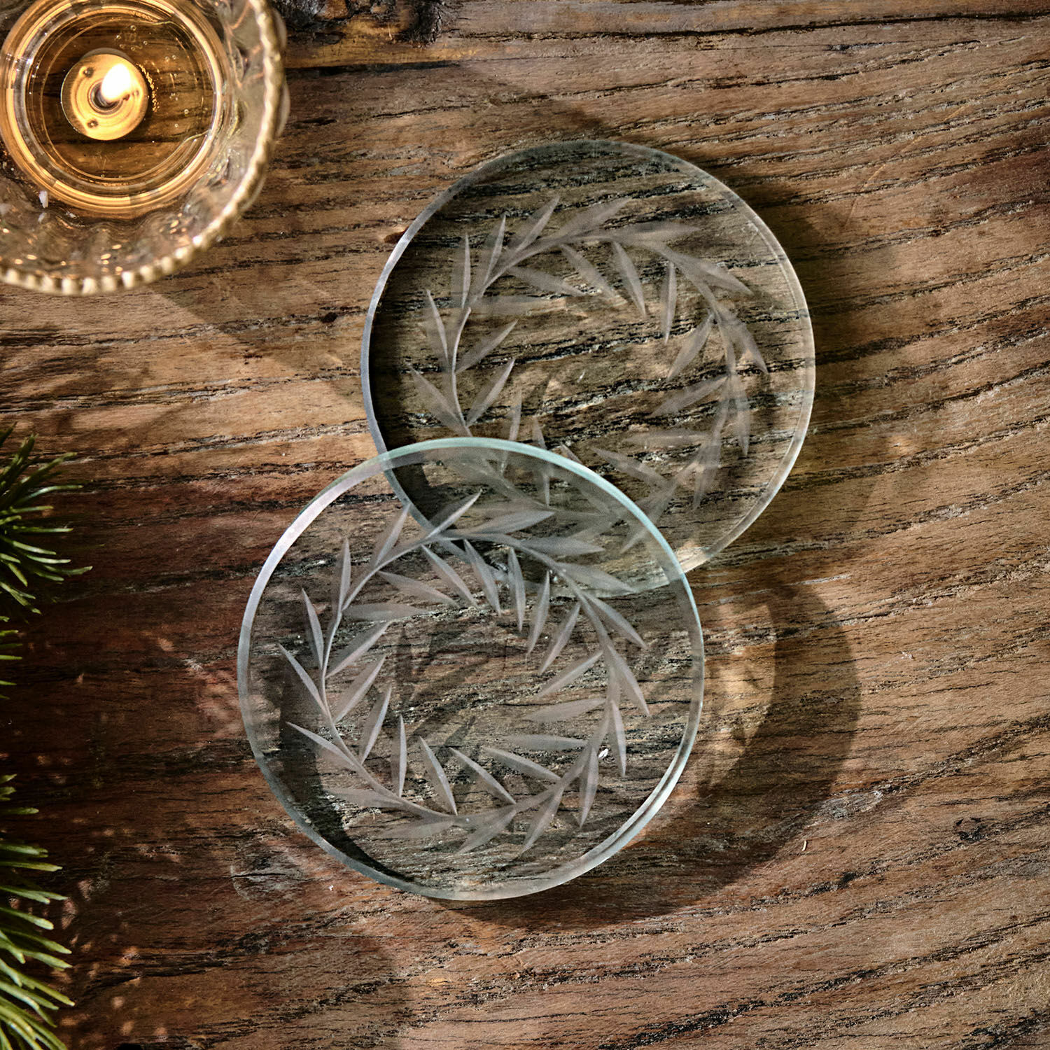 Lot de 2 dessous de verre Altheris Sous-verres en verre transparent avec motif gravé de feuilles sur table en bois, décoration élégante
