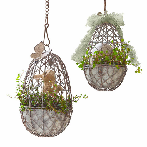 Hangende metalen manddecoratie in eivorm met groene planten en kaars binnenin