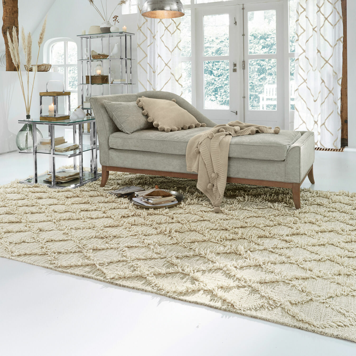 Chaise longue grise en tissu avec pieds en bois sur tapis beige dans un salon lumineux