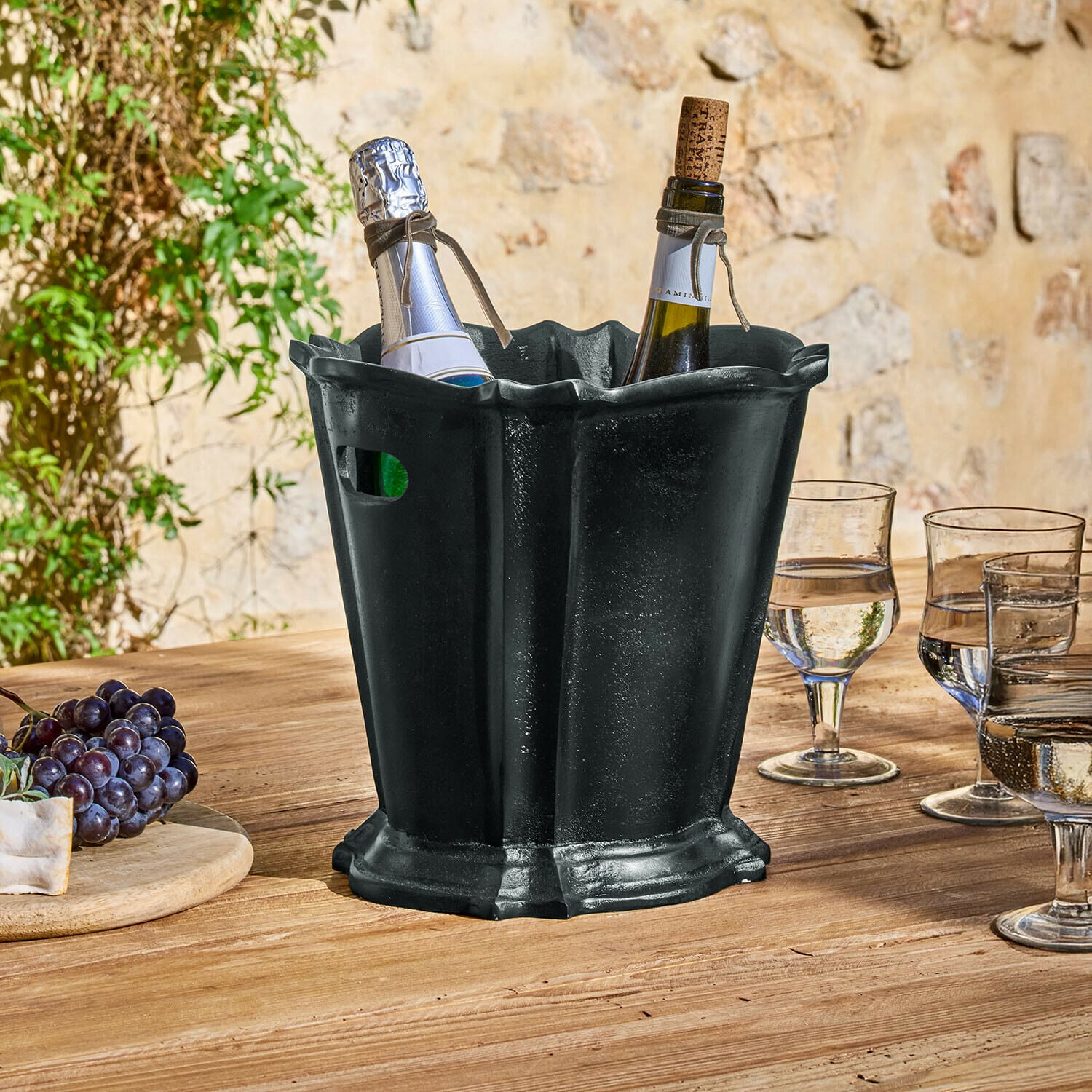 Drankenkoeler Trévaux Zwarte metalen ijsemmer met twee wijnflessen op houten tafel buiten