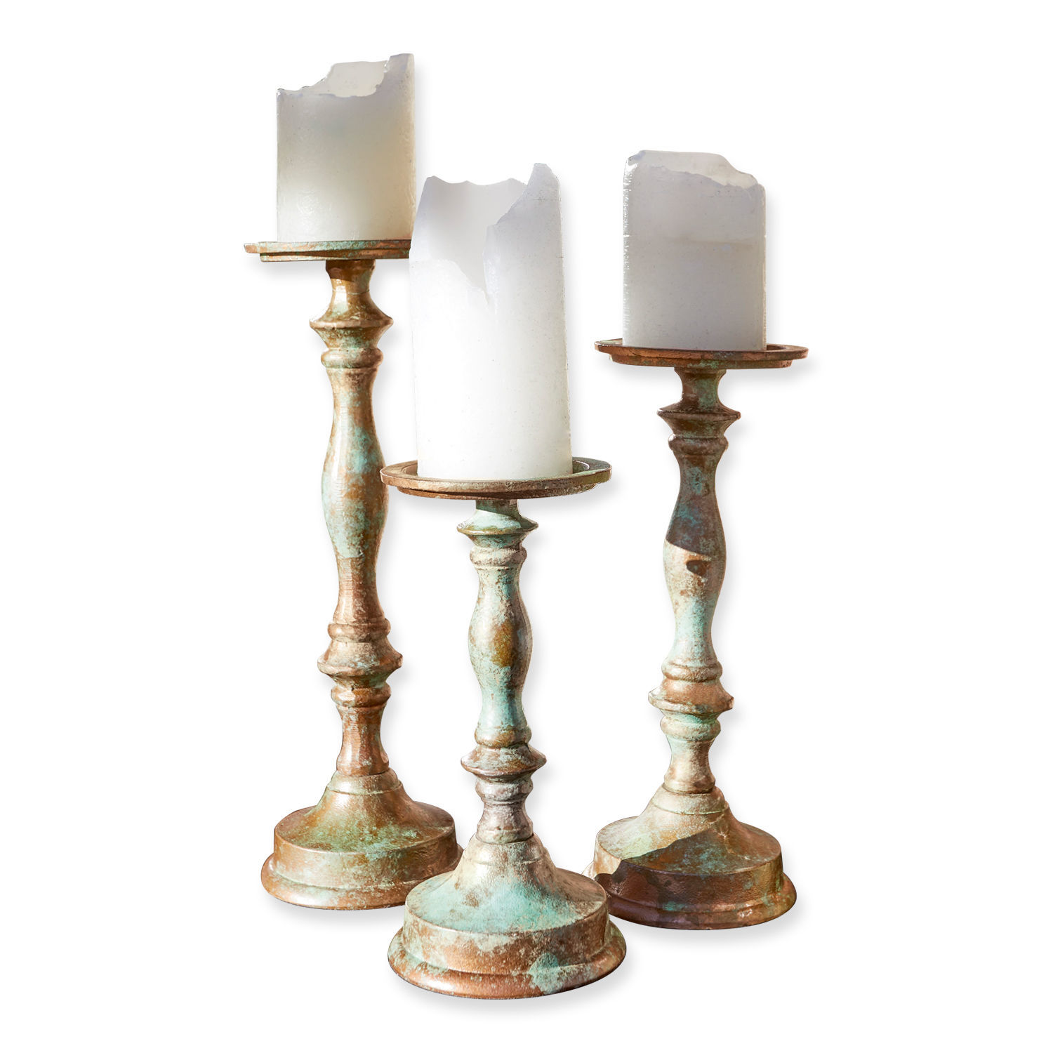 Ensemble de trois bougeoirs en métal patiné avec des bougies blanches décoratives