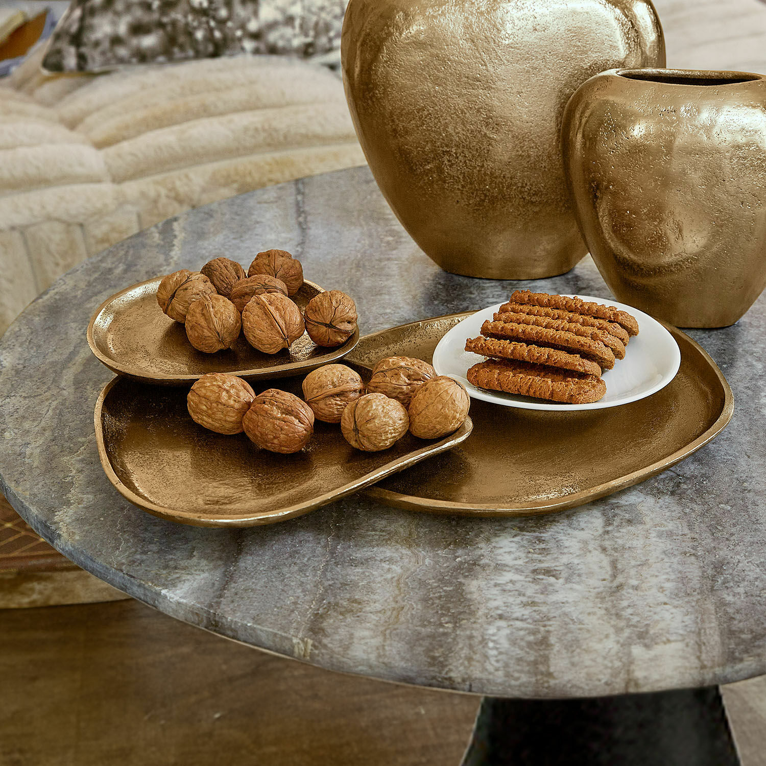 Schaal Zampillo Set gouden metalen schalen en vazen op marmeren tafel met noten en koekjes