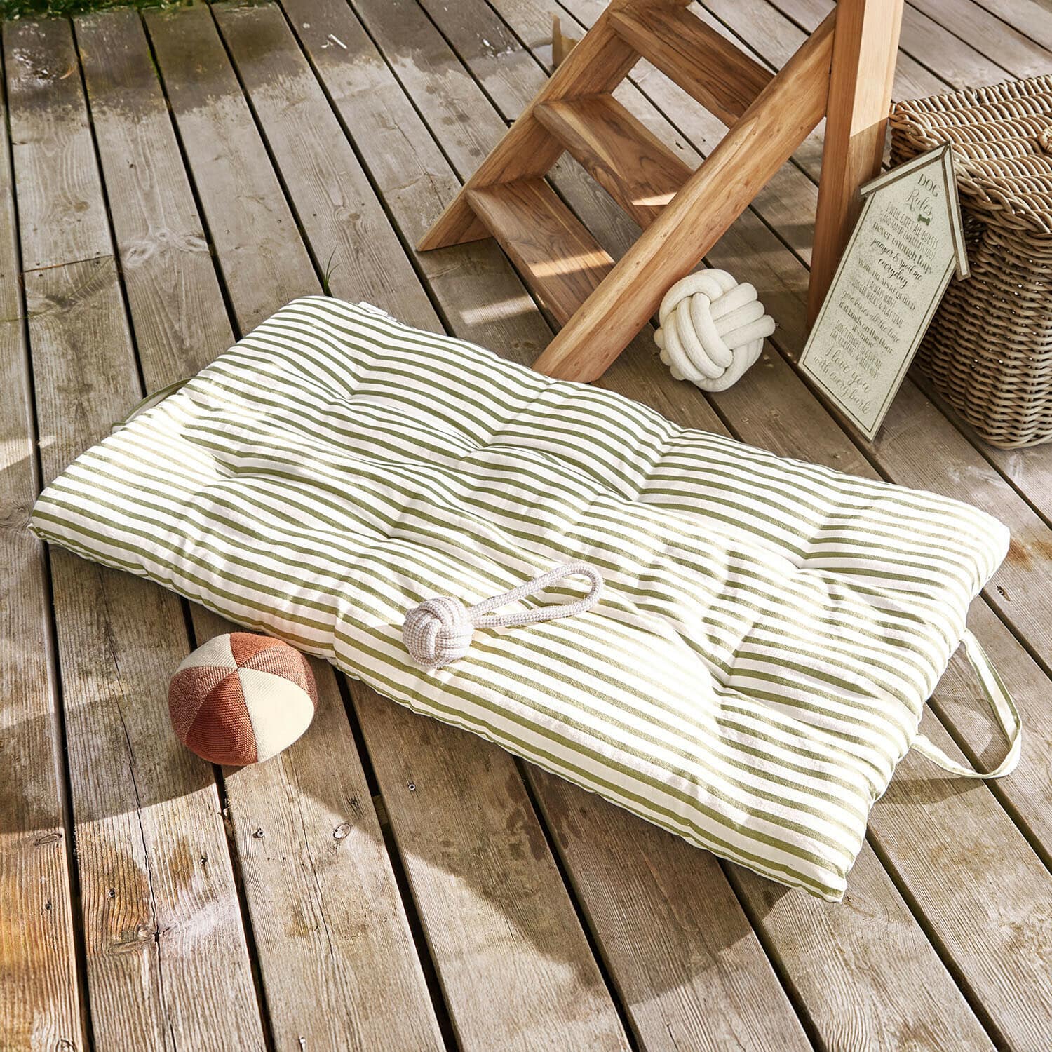 Matras voor huisdieren Selinah Gewatteerd kussen met groene strepen op houten terras met hondenspeelgoed