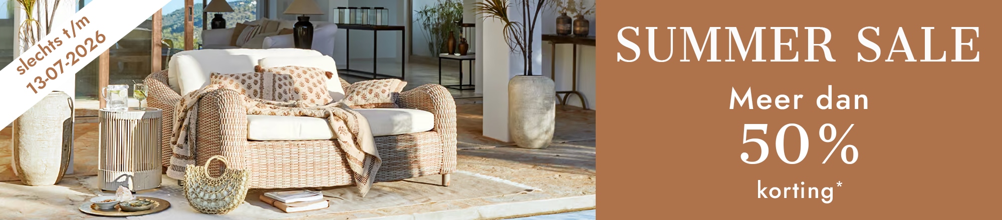 Zomersale met meer dan 50% korting, gezellige woonkamer met rotan bank en lichte kussens