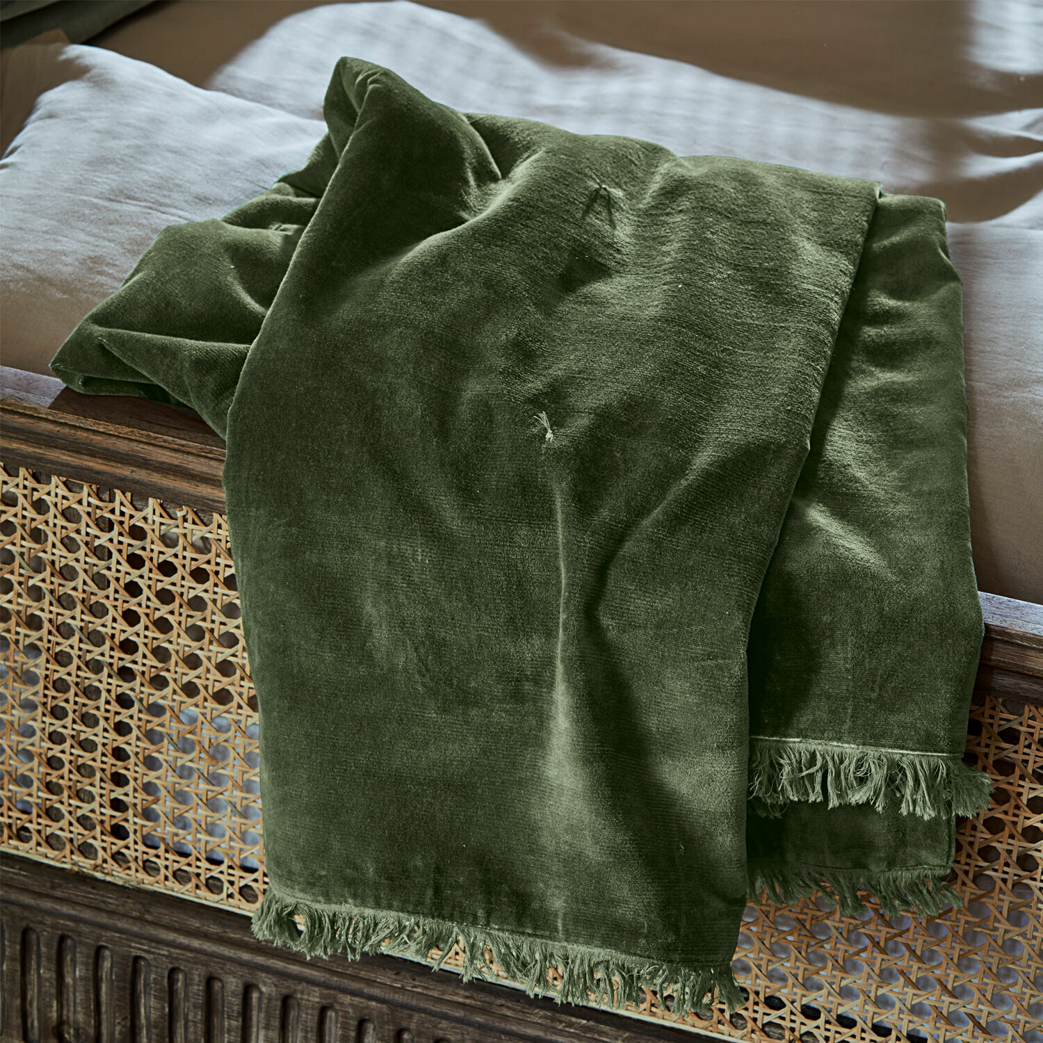 Plaid Maelis Plaid vert en velours avec franges sur un lit en bois, textile doux et décoratif pour chambre à coucher