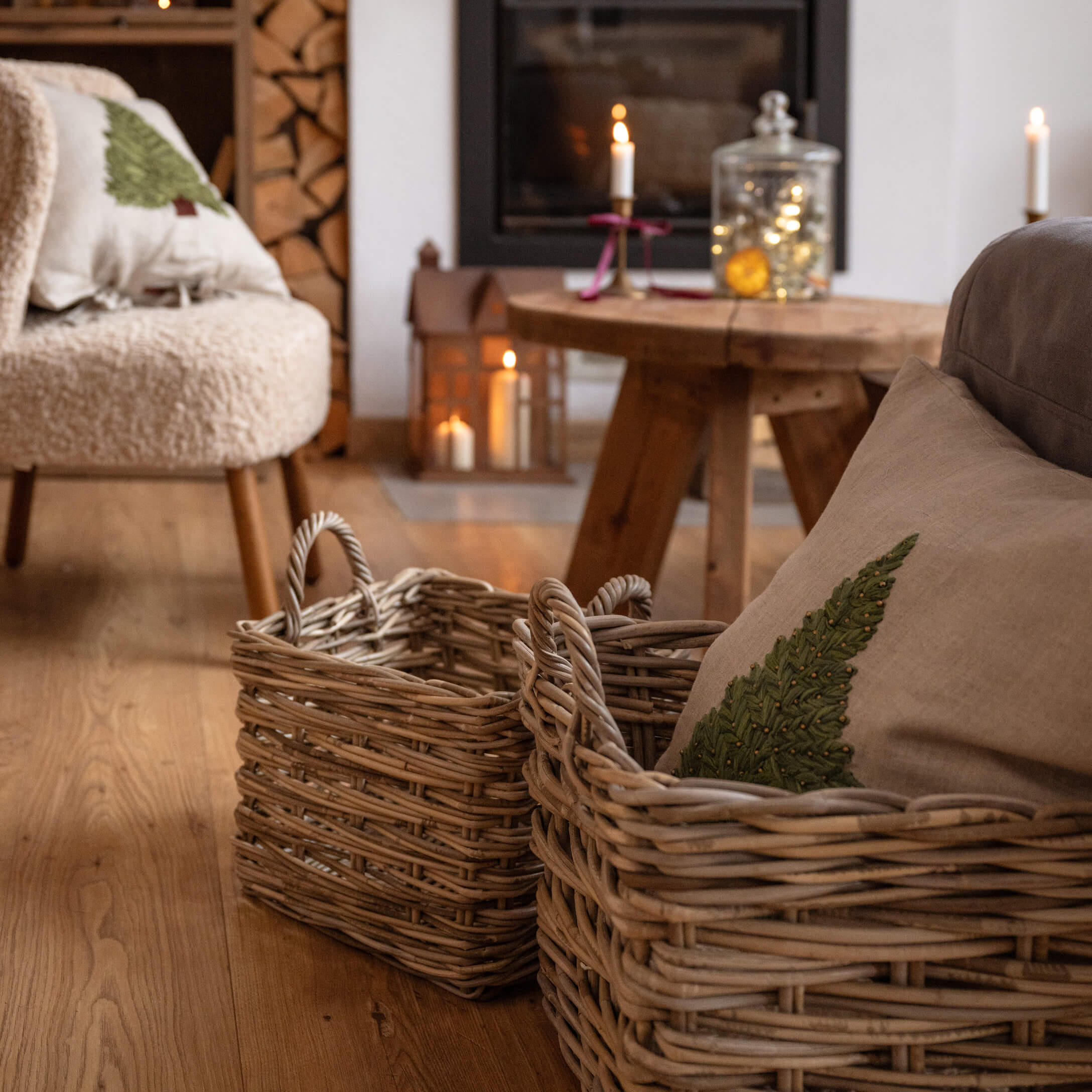 Twee natuurlijke rieten manden op houten vloer in gezellige woonkamer met open haard
