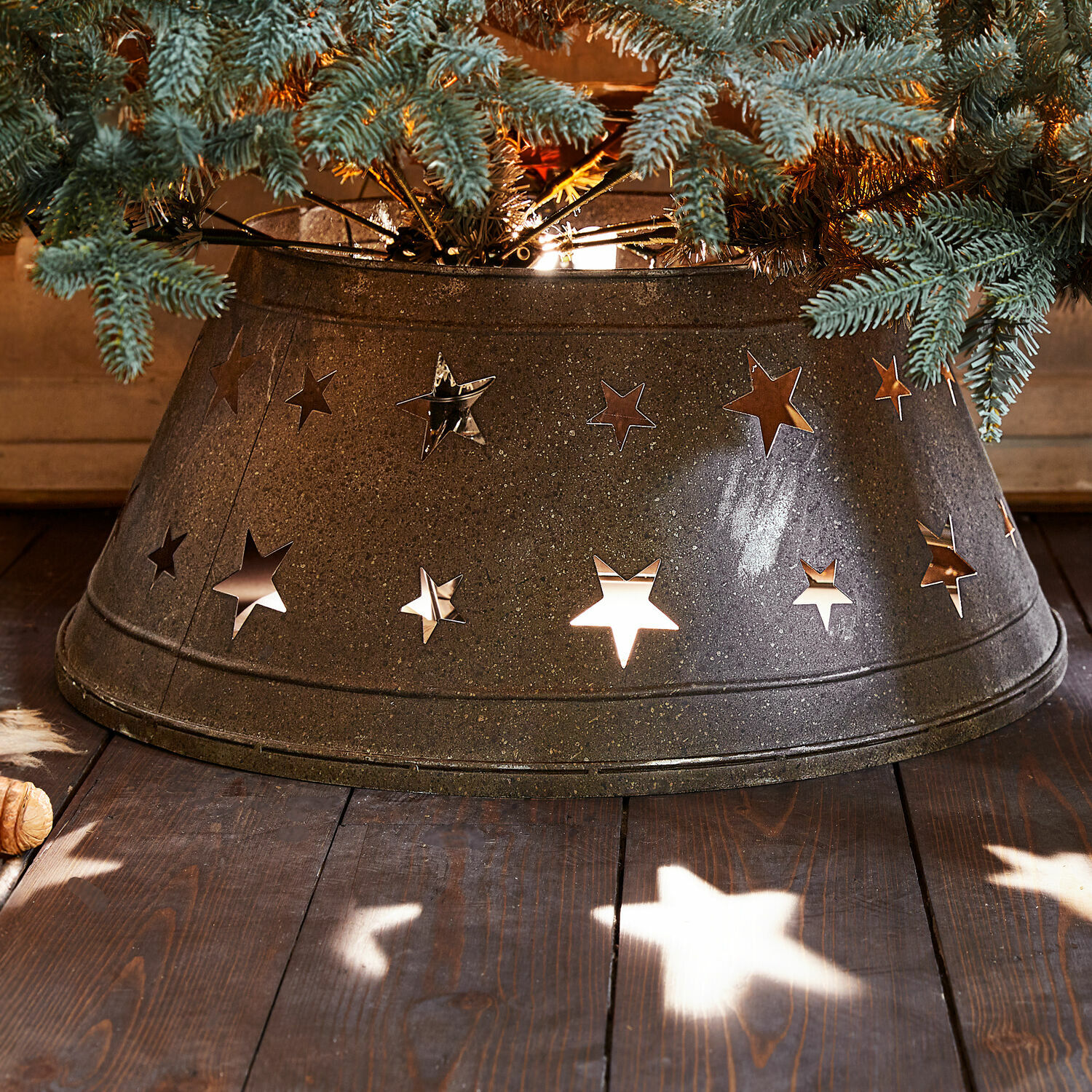 Kerstboompot Ysabelle Metalen kerstboomstandaard met stervormige uitsparingen, donkergrijze kerstdecoratie op houten vloer