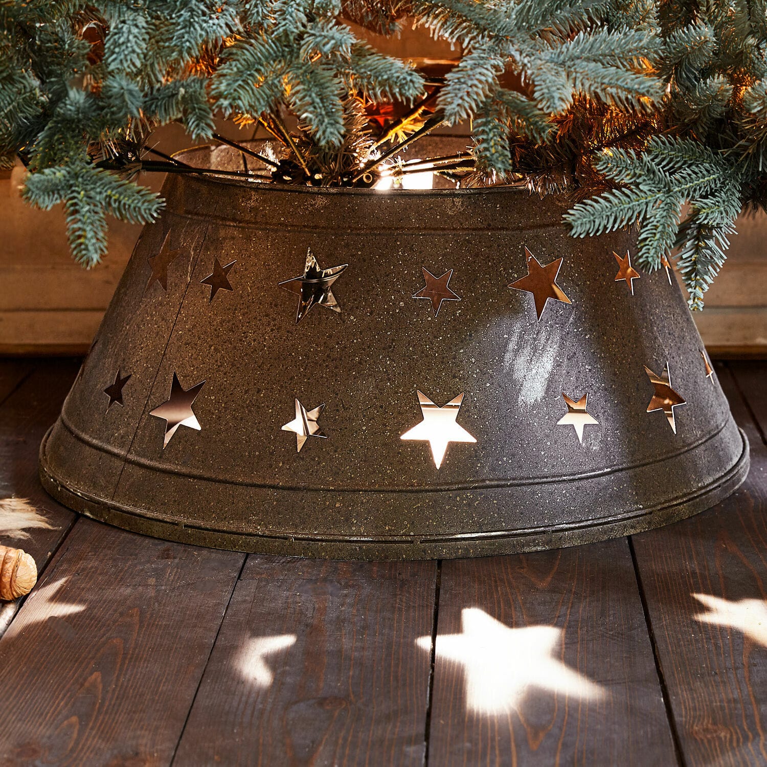 Kerstboompot Ysabelle Metalen kerstboomstandaard met stervormige uitsparingen, donkergrijze kerstdecoratie op houten vloer