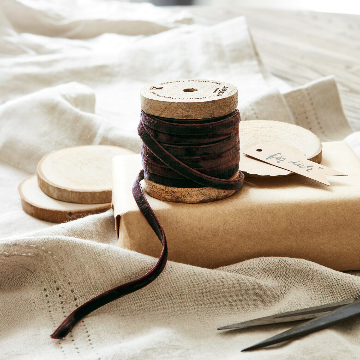 Ruban en velours marron sur bobine en bois avec décorations naturelles et ciseaux pour emballage cadeau