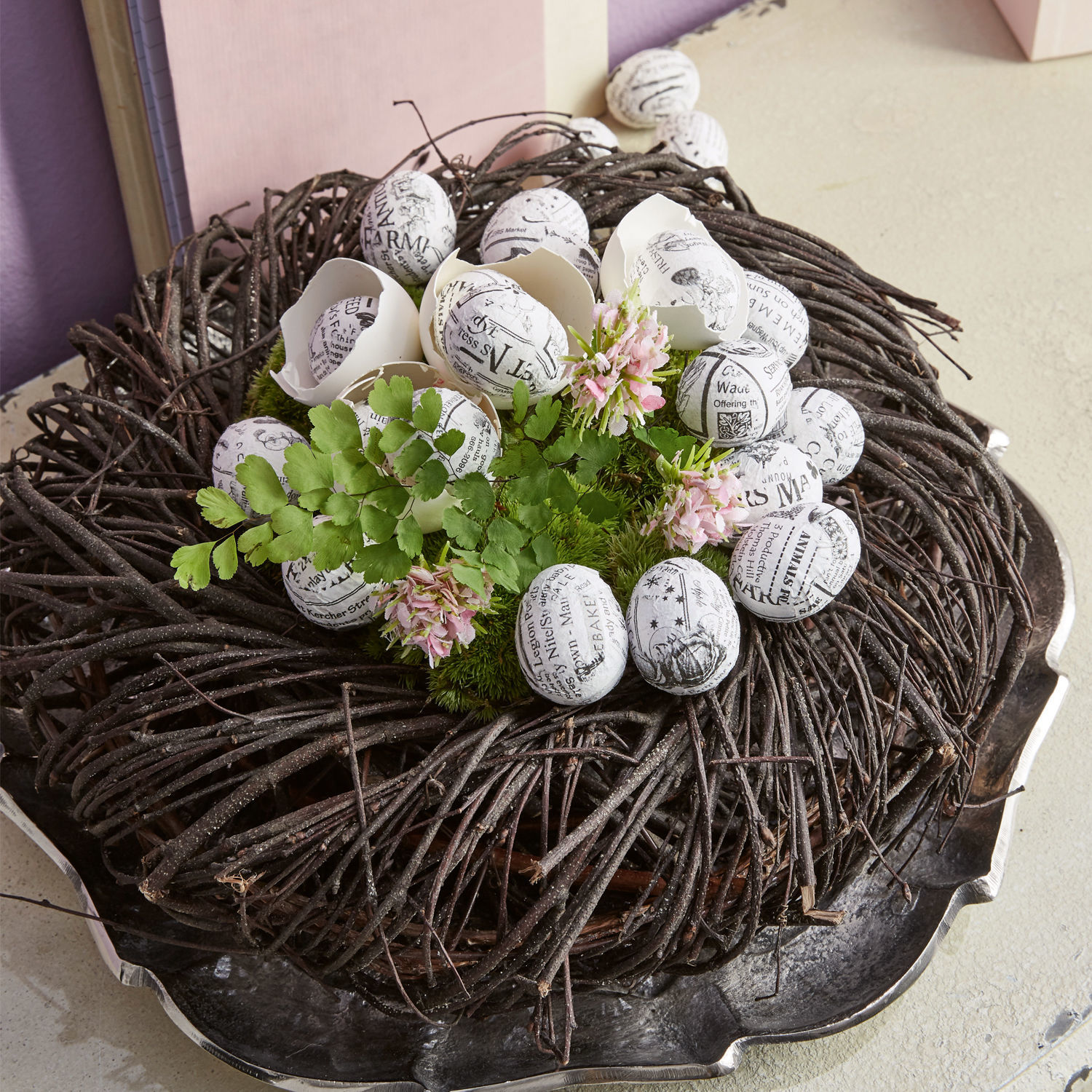 Couronne décorative en branches avec œufs blancs imprimés en noir et feuilles vertes pour décoration intérieure