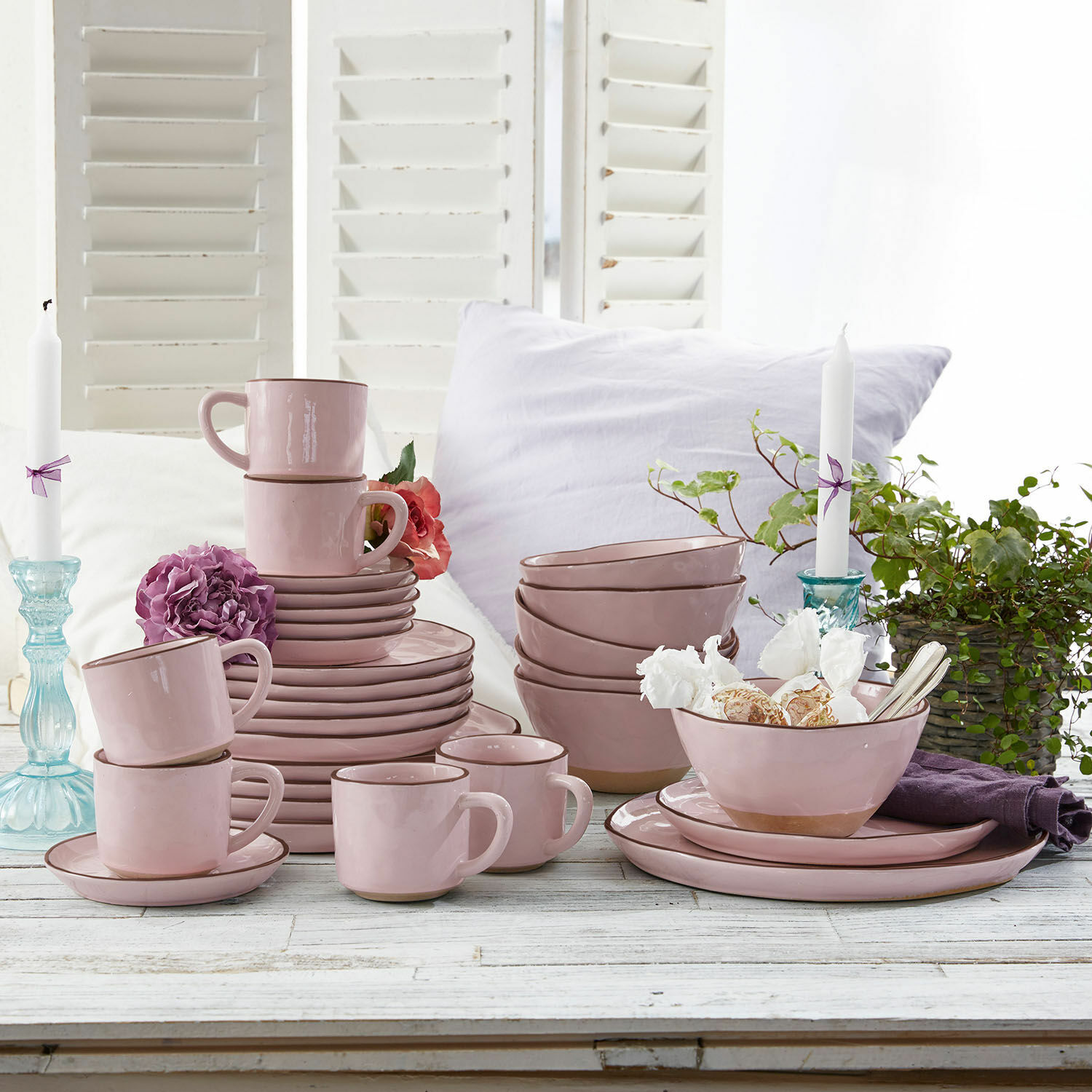 Servies set van 30 Biarré Roze keramisch servies met kopjes, borden en kommen op een witte houten tafel