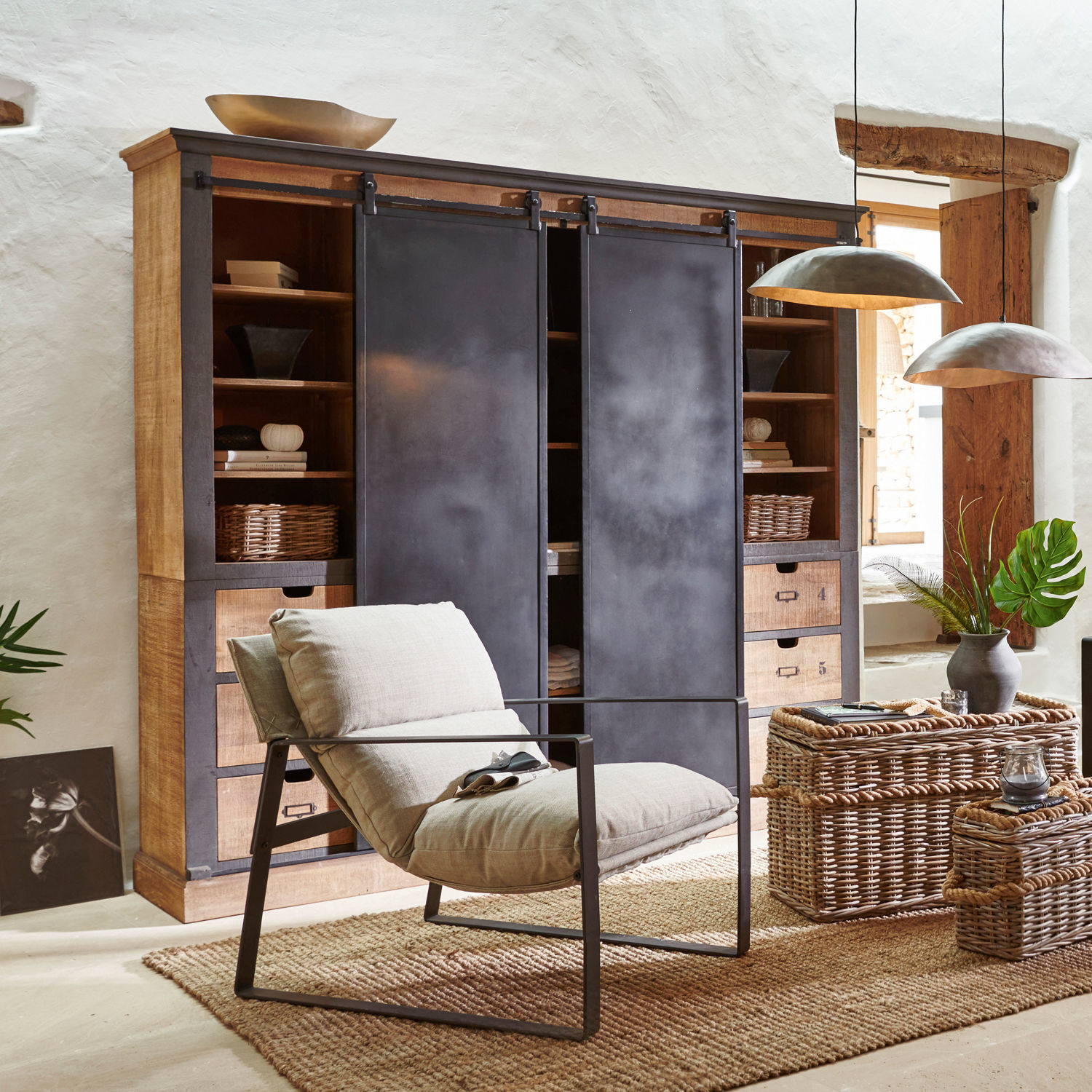 Armoire Vulmont Fauteuil moderne en métal avec coussin beige dans un salon naturel avec paniers en osier