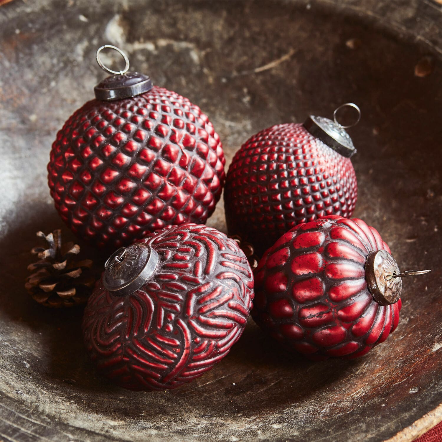 Kerstversiering set van 4 Meyen Vier rode kerstballen met verschillende texturen in een houten schaal, feestelijke decoratie