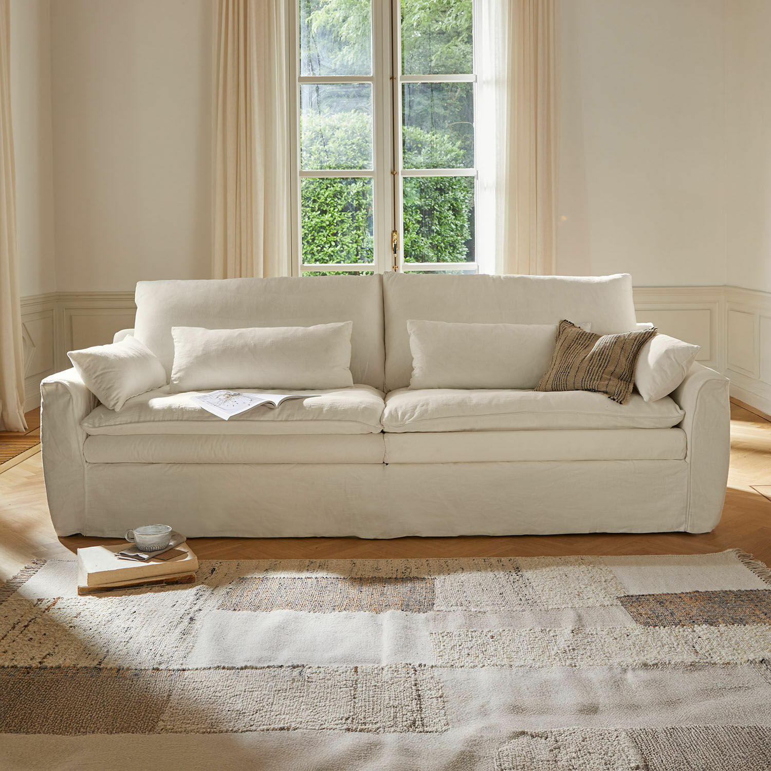 Bank Dunhaven Beige stoffen bank met kussens en lichte vloerkleed in een gezellige woonkamer