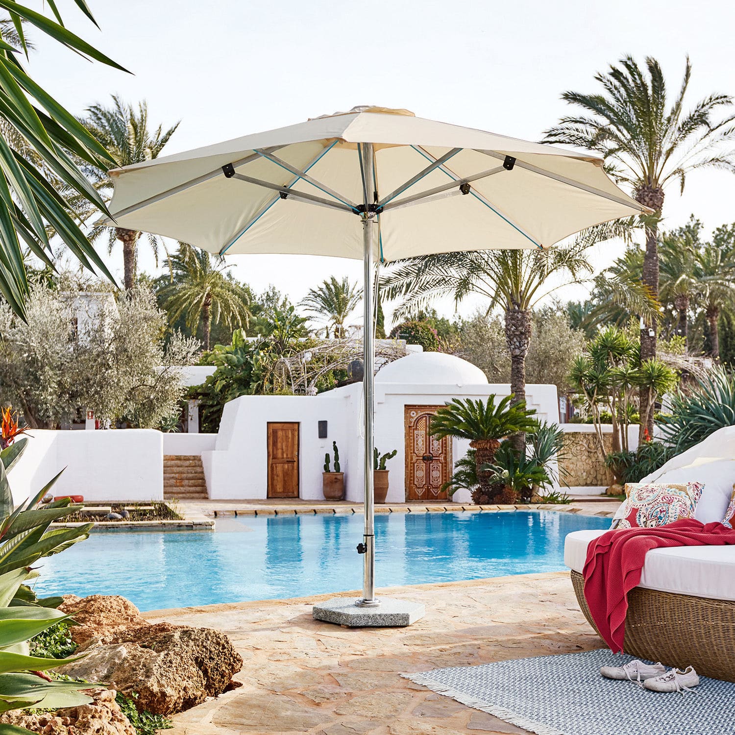 Parasol Thompson Grand parasol de jardin crème avec structure métallique au bord d'une piscine dans un cadre élégant