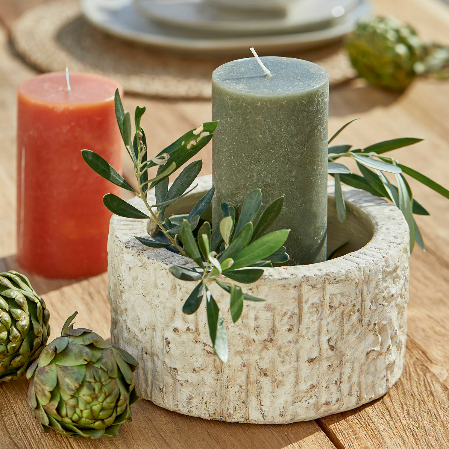 Schaal Continas Ronde beige stenen kandelaar met groene kaars en bladdecoratie op houten tafel
