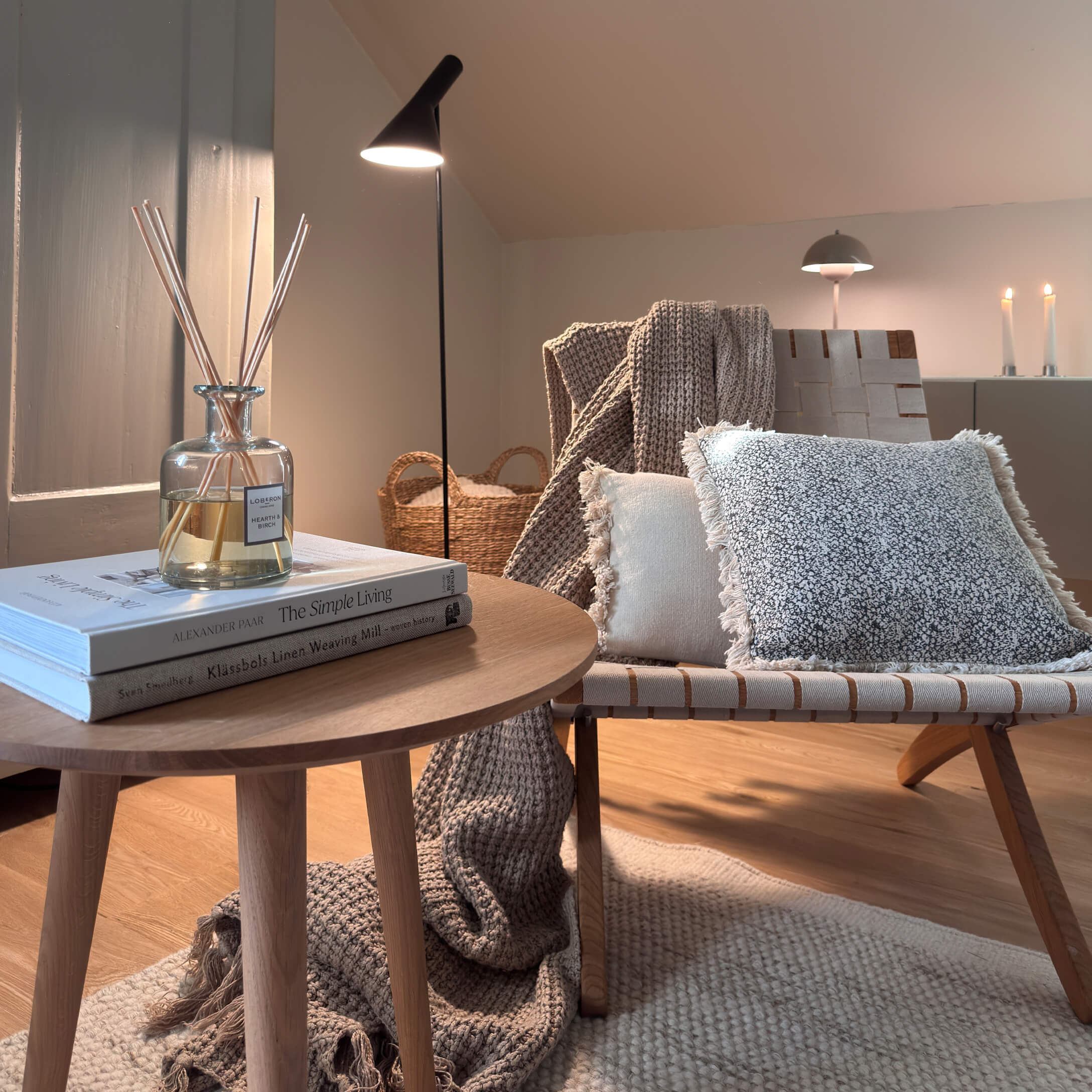 Coin cosy avec table en bois, lampe et coussins doux aux tons naturels pour un intérieur chaleureux